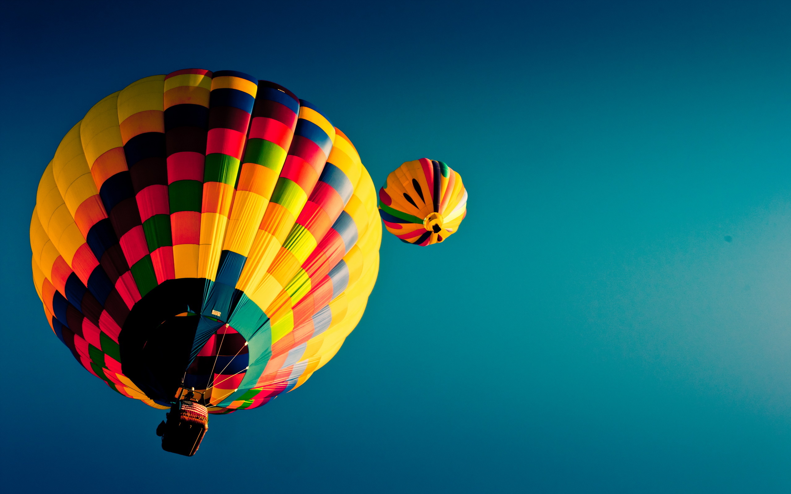 Two colorful hot air balloons in a clear blue sky HD Wallpaper