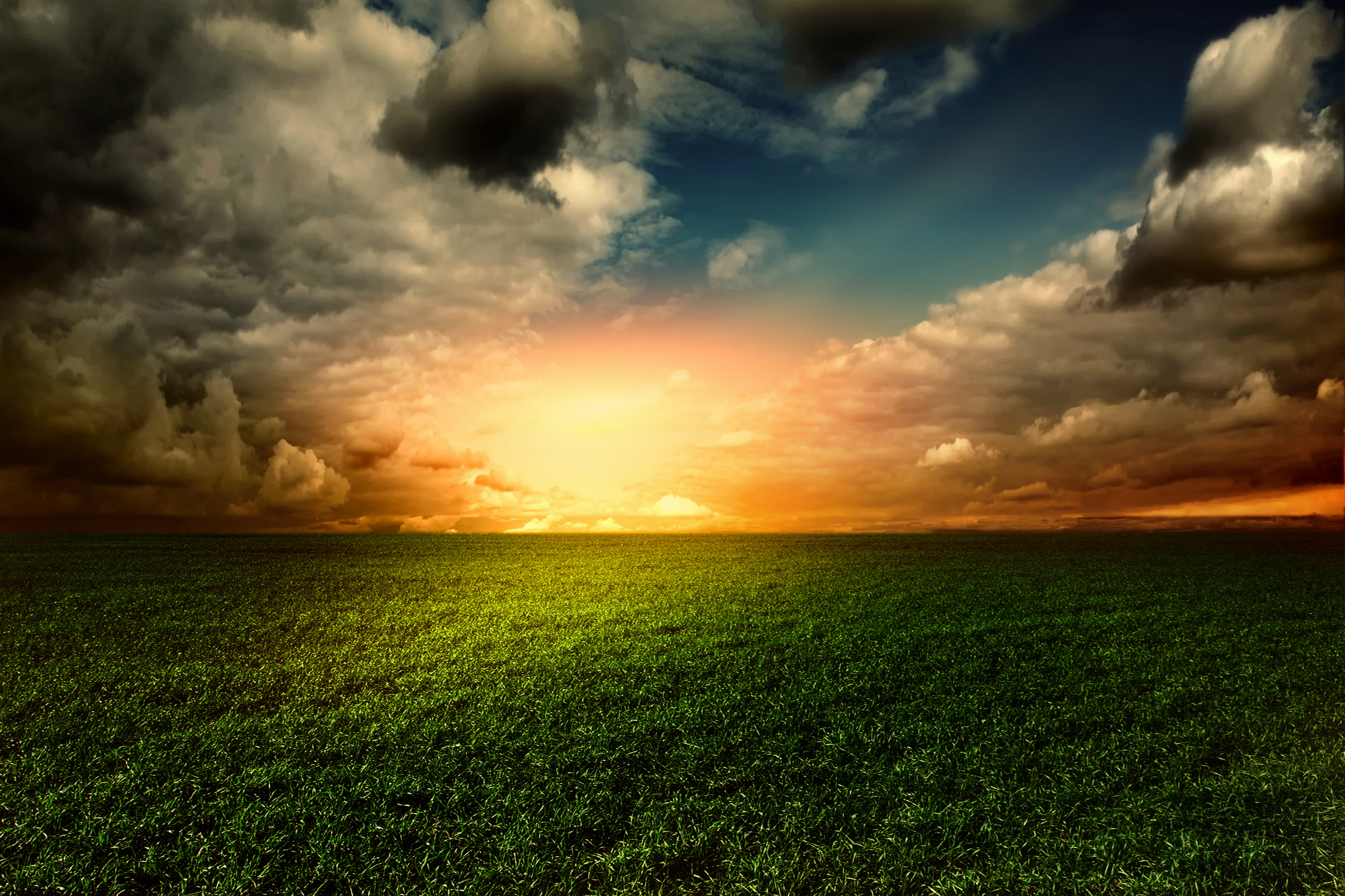 Sunset over a green field with dramatic clouds HD Wallpaper