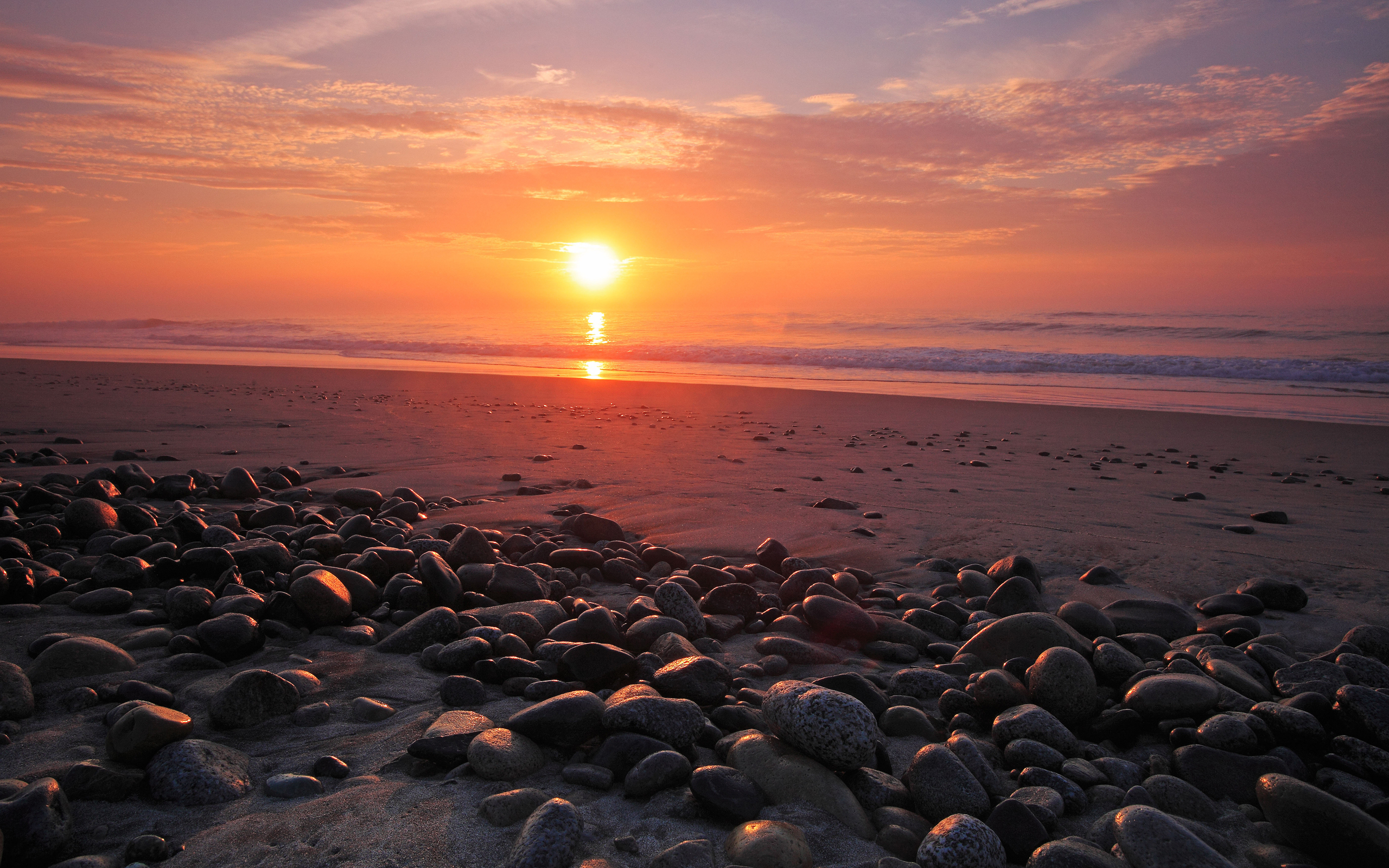 Sunset over a rocky beach with ocean waves HD Wallpaper