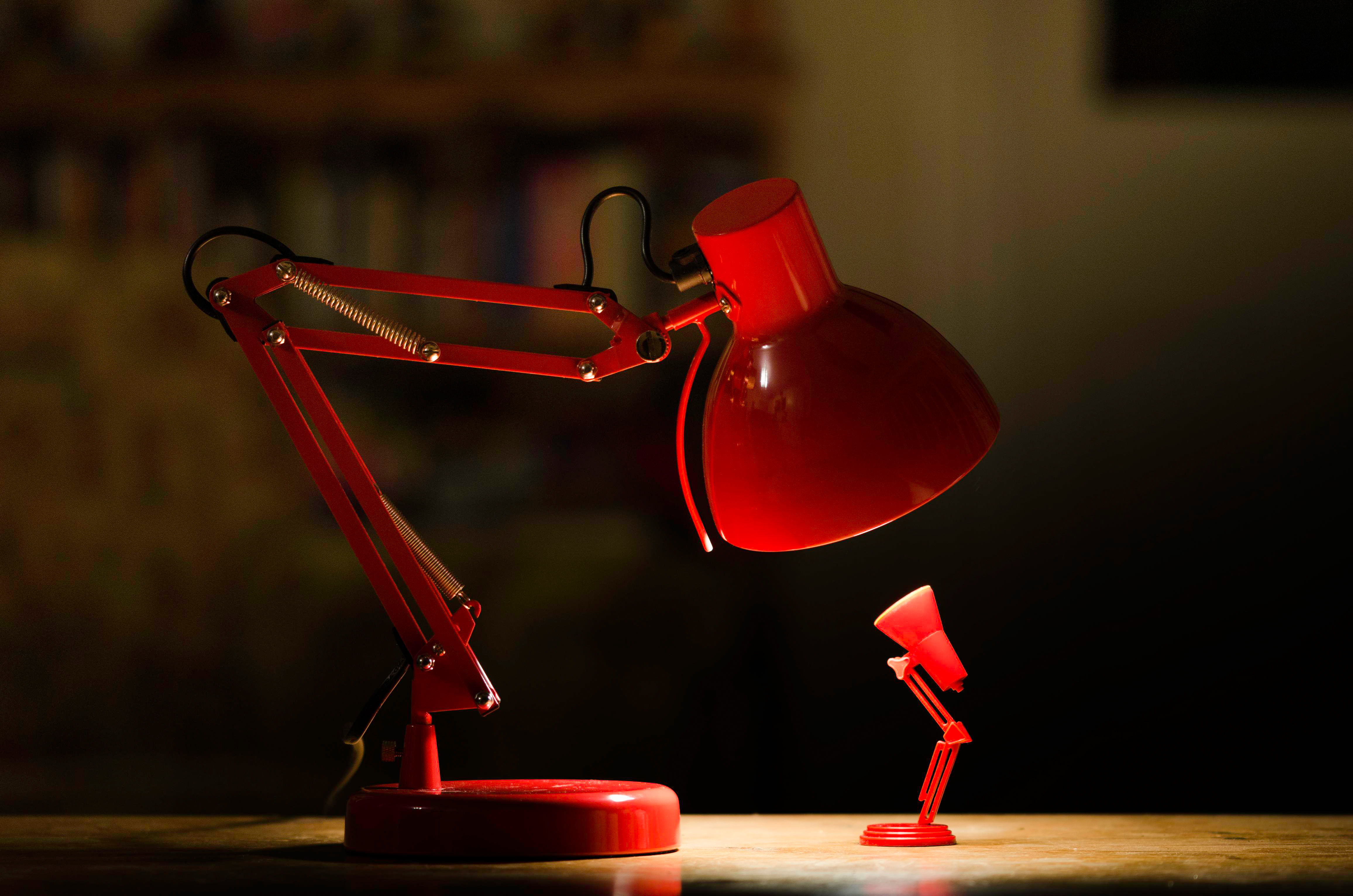 Two red desk lamps, one large and one small HD Wallpaper