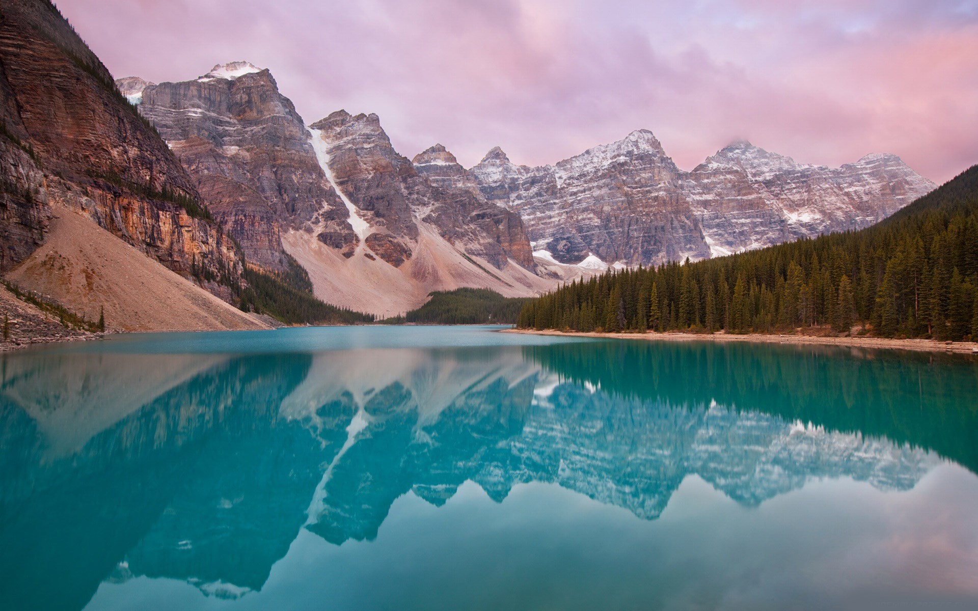 Turquoise lake reflecting snow-capped mountains and pine forest HD Wallpaper