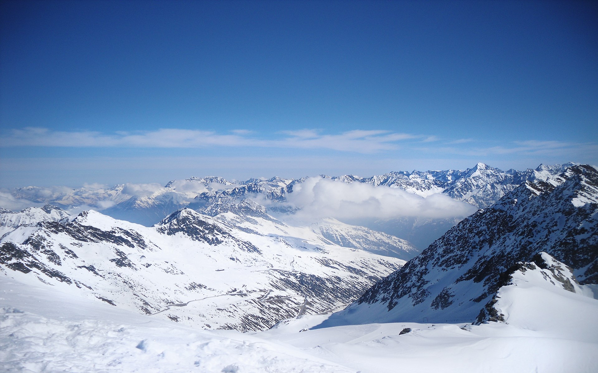 Snow-covered mountains under a clear blue sky HD Wallpaper