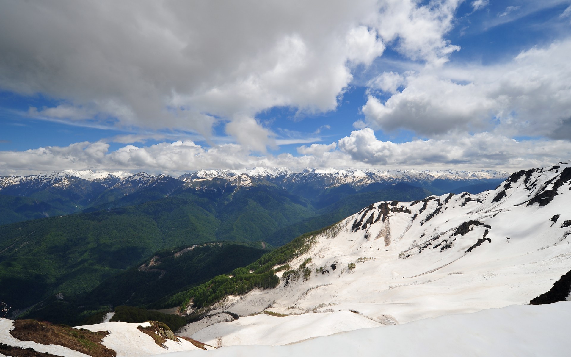 Snow-capped mountains under a cloudy sky HD Wallpaper