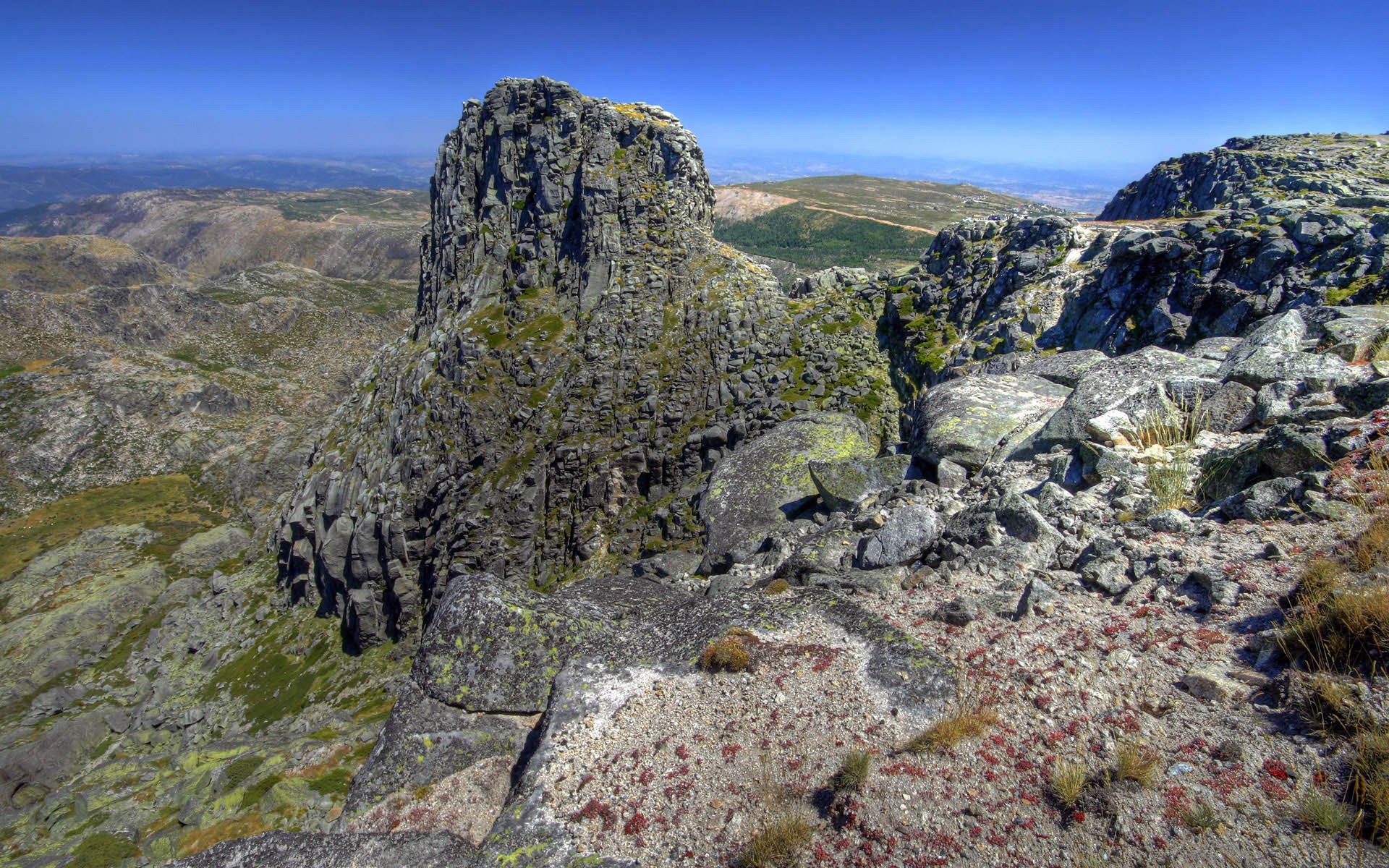 Rocky mountain peak with vast landscape under blue sky HD Wallpaper