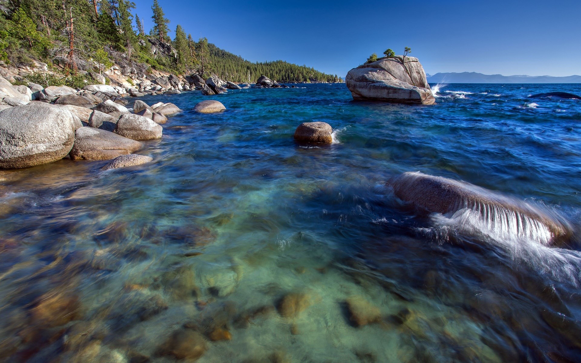 Lake Tahoe shoreline with clear blue water and rocks HD Wallpaper