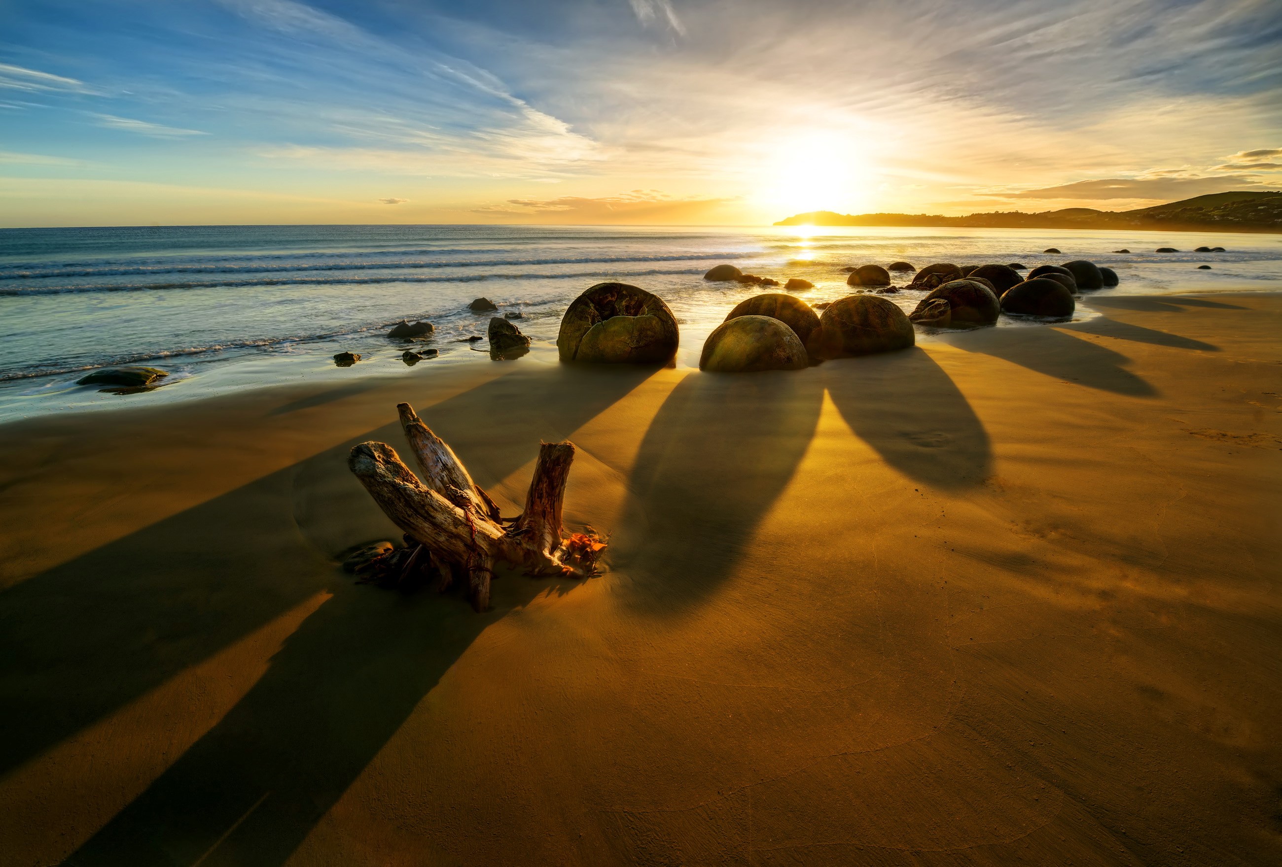 Moeraki Boulders beach at sunrise with driftwood HD Wallpaper