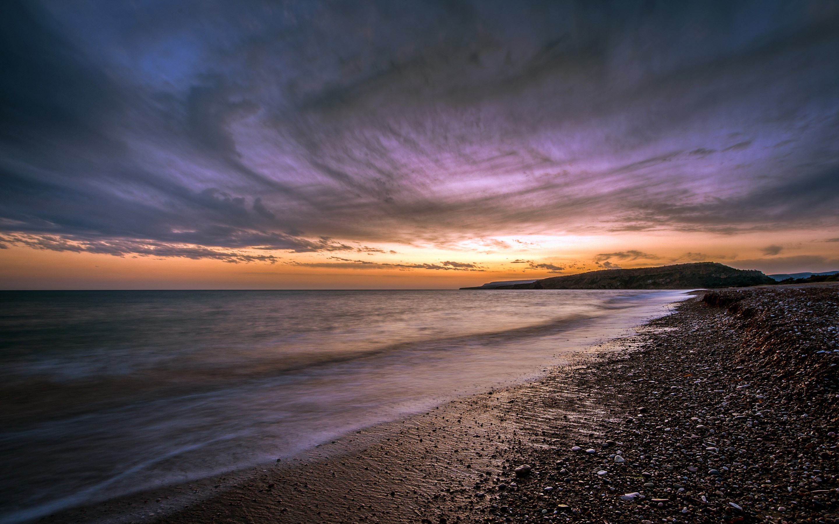 Sunset over a pebble beach and calm sea HD Wallpaper