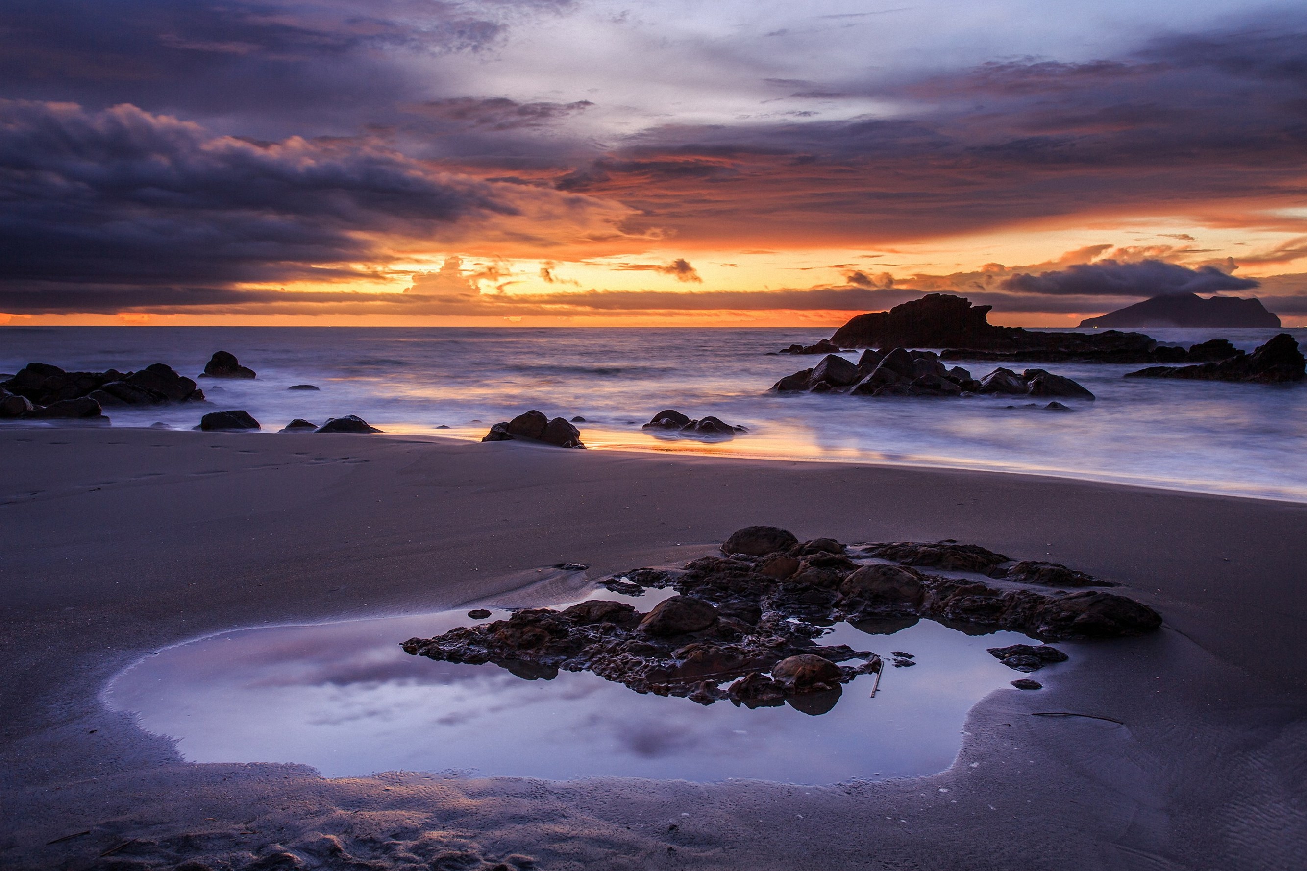 Beach with rocks and ocean at sunset HD Wallpaper