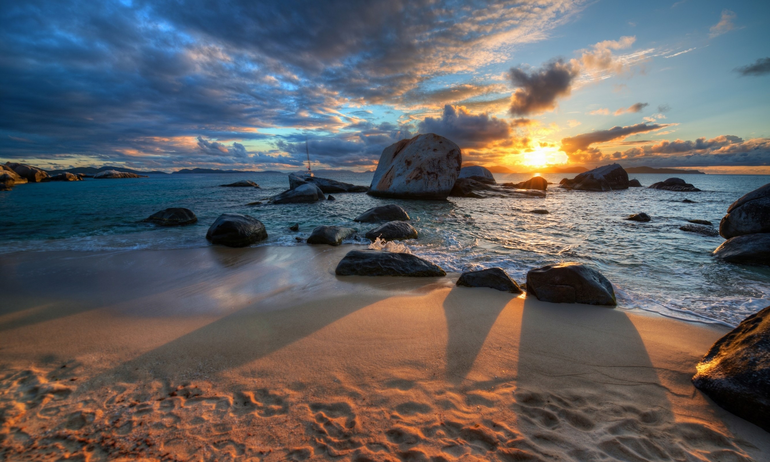 Sunset over a rocky beach with waves HD Wallpaper