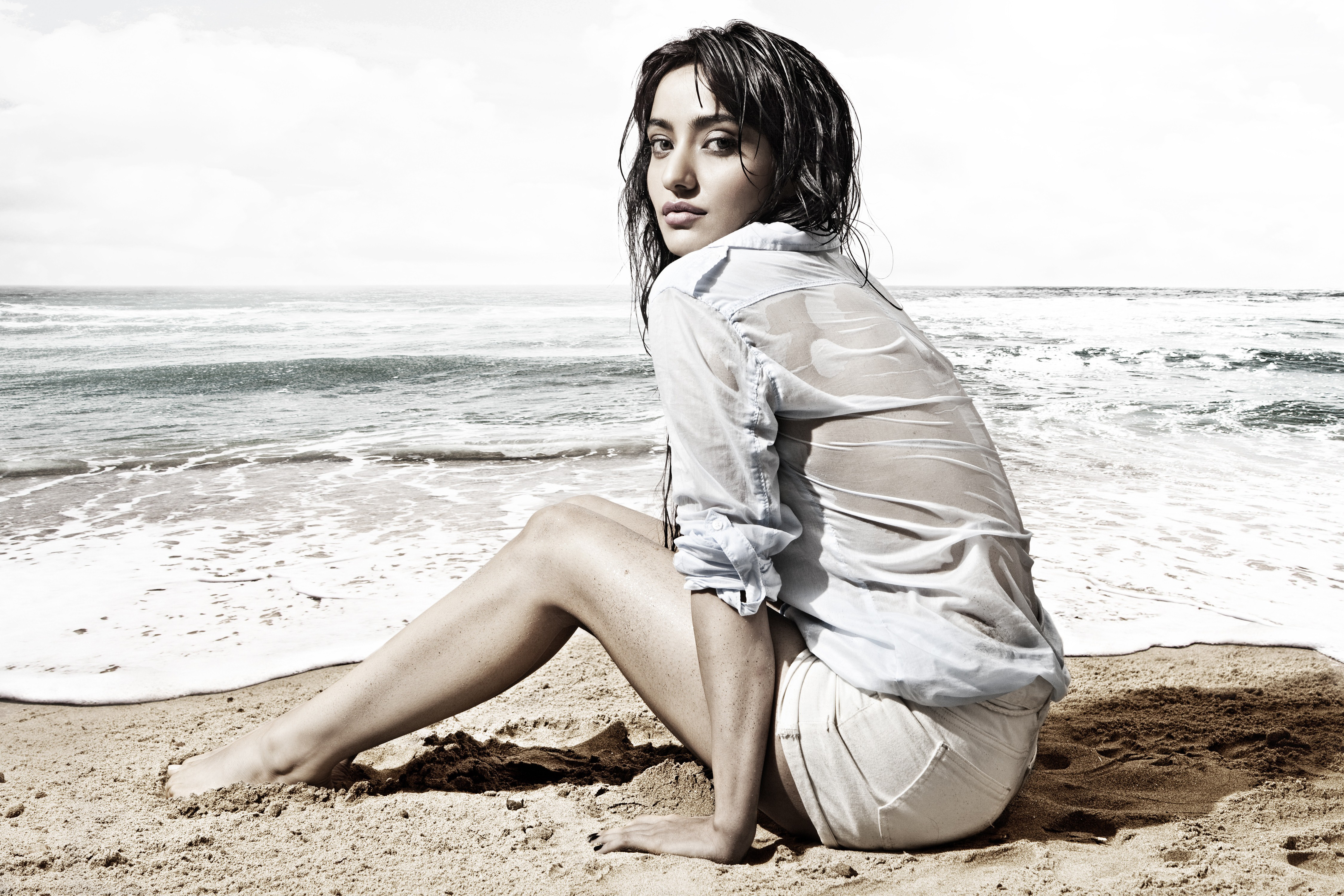 Neha Sharma sitting on a beach HD Wallpaper