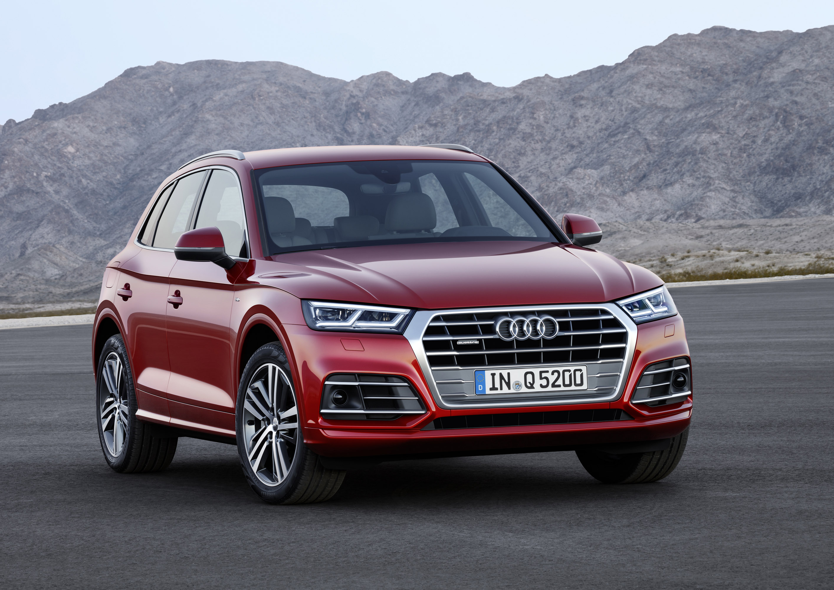 Red Audi Q5 SUV parked on asphalt with mountains in background HD Wallpaper
