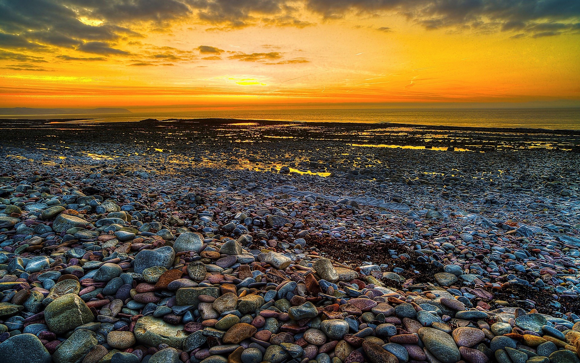 Rocky beach at sunset with ocean and clouds HD Wallpaper