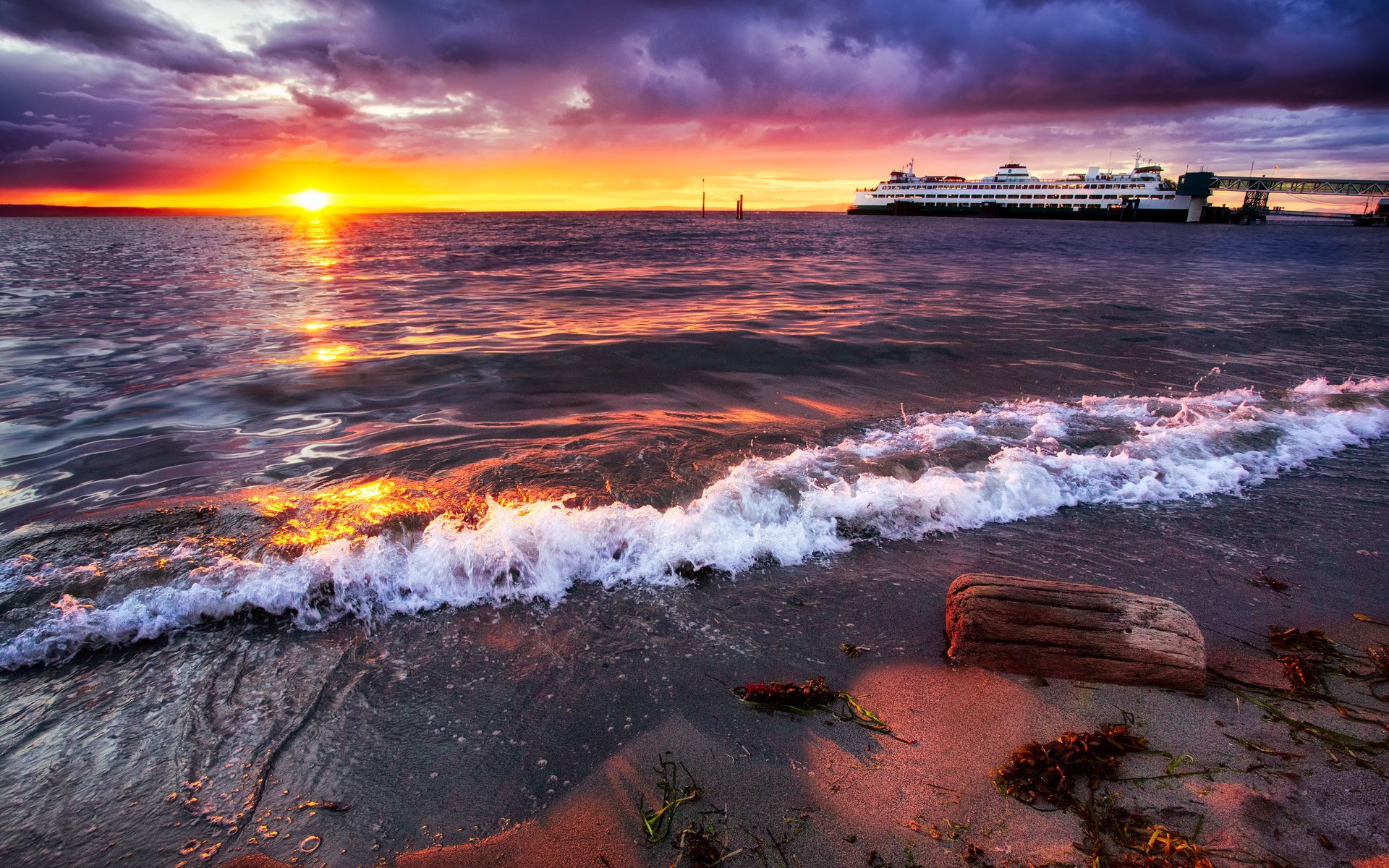 Ferry docked at sunset with waves on the shore HD Wallpaper