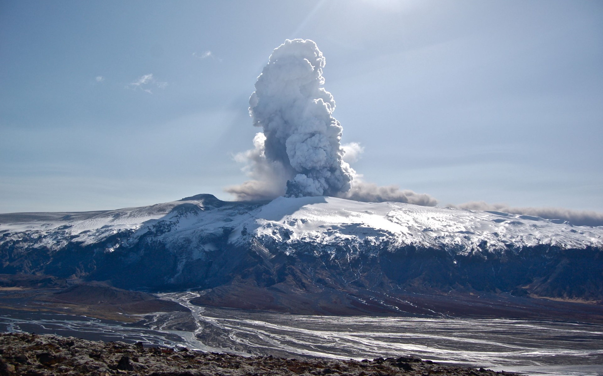 Volcano erupting ash cloud over snowy mountain HD Wallpaper