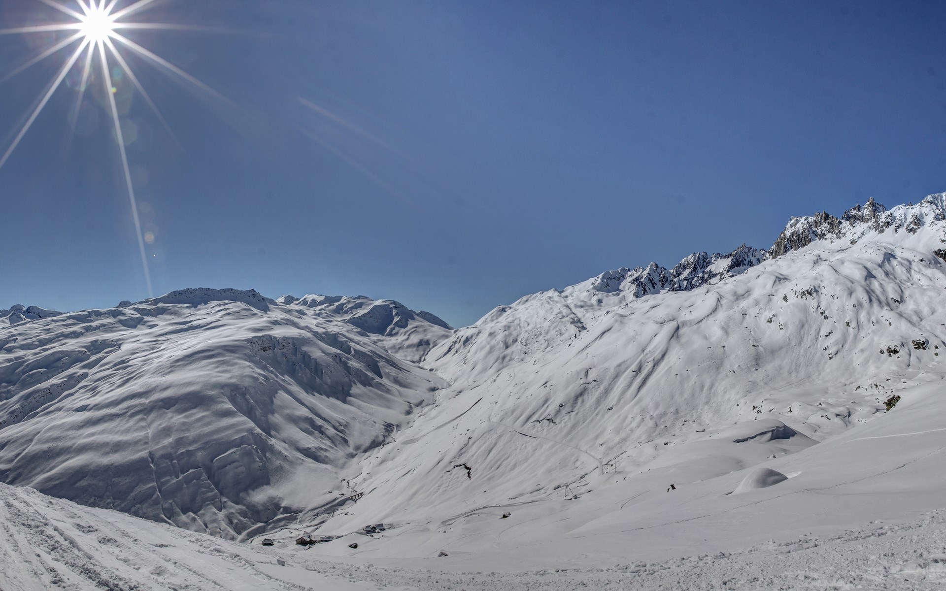 Snowy mountains under a bright sun HD Wallpaper