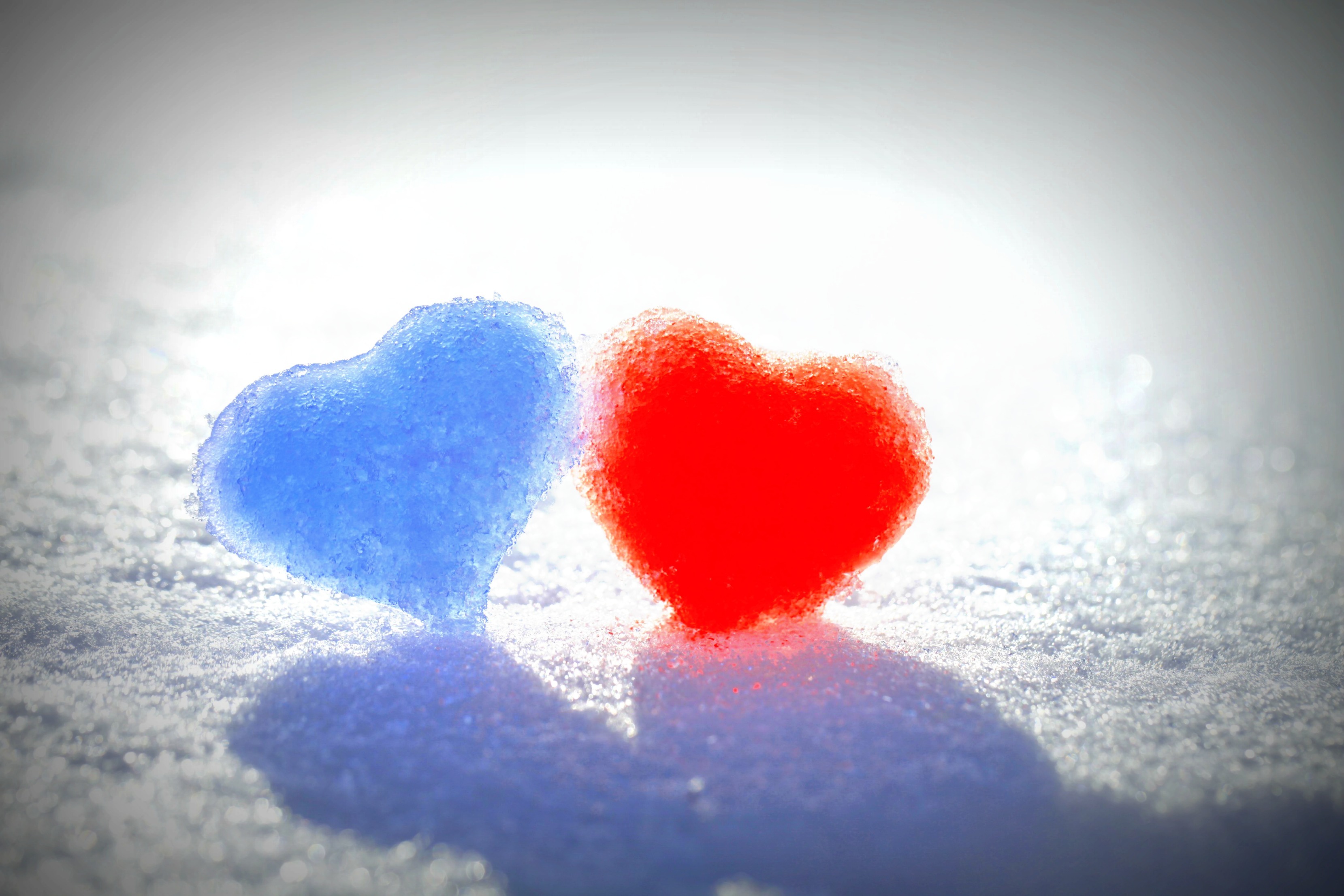 Two frozen hearts, one red and one blue, in the snow HD Wallpaper