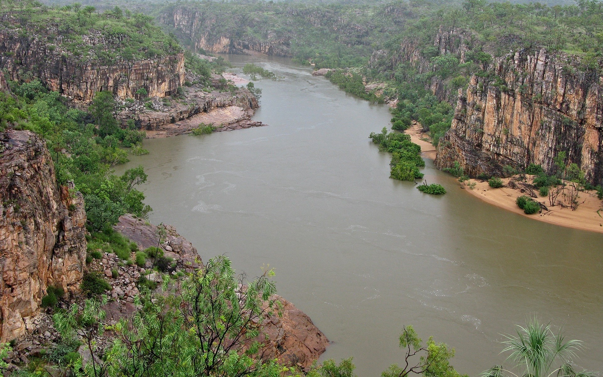 River flowing through a rocky canyon with green vegetation HD Wallpaper