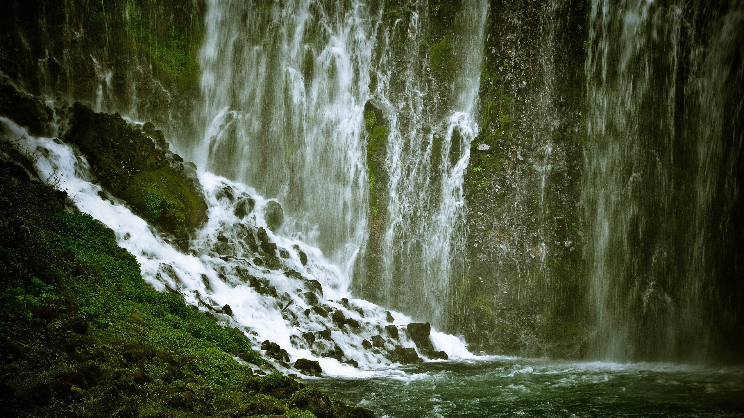 Waterfall cascading over mossy rocks into a pool HD Wallpaper