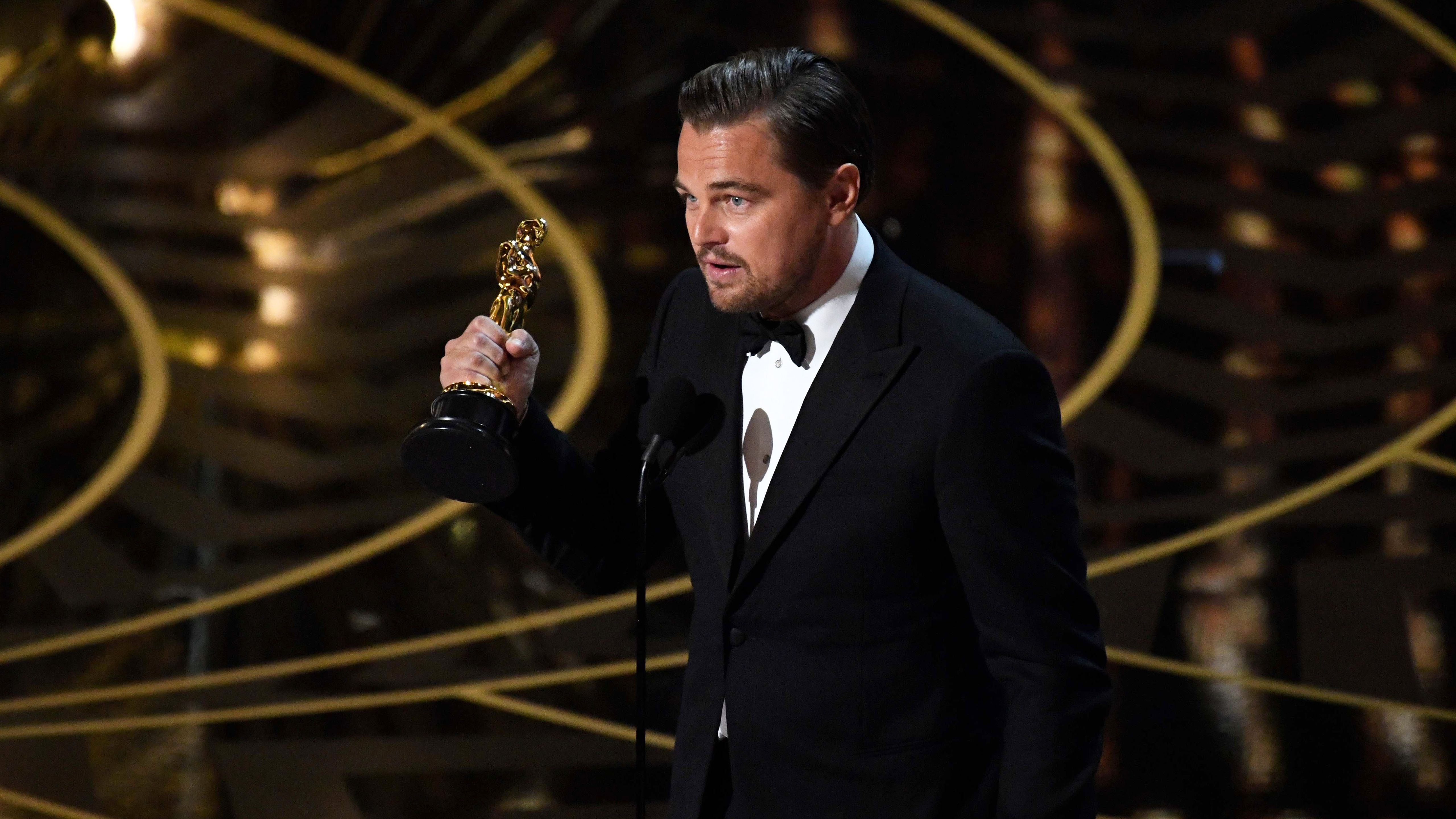 Leonardo DiCaprio holding an Academy Award HD Wallpaper