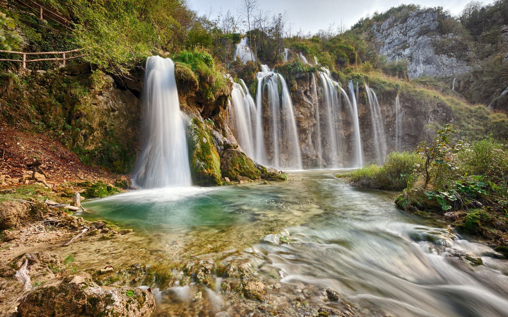 Waterfalls cascading into a clear turquoise pool HD Wallpaper