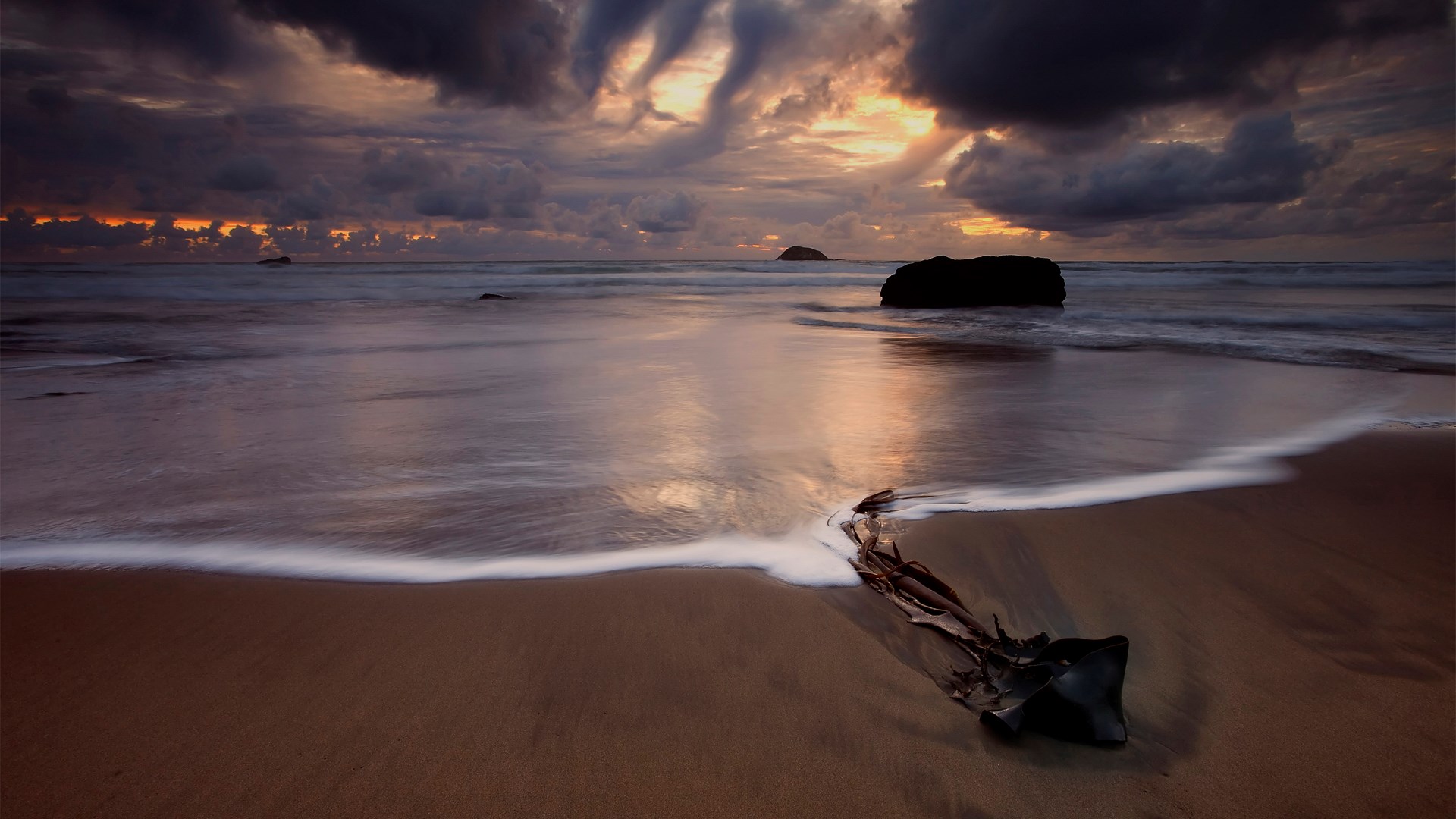 Beach at sunset with dramatic clouds and waves HD Wallpaper