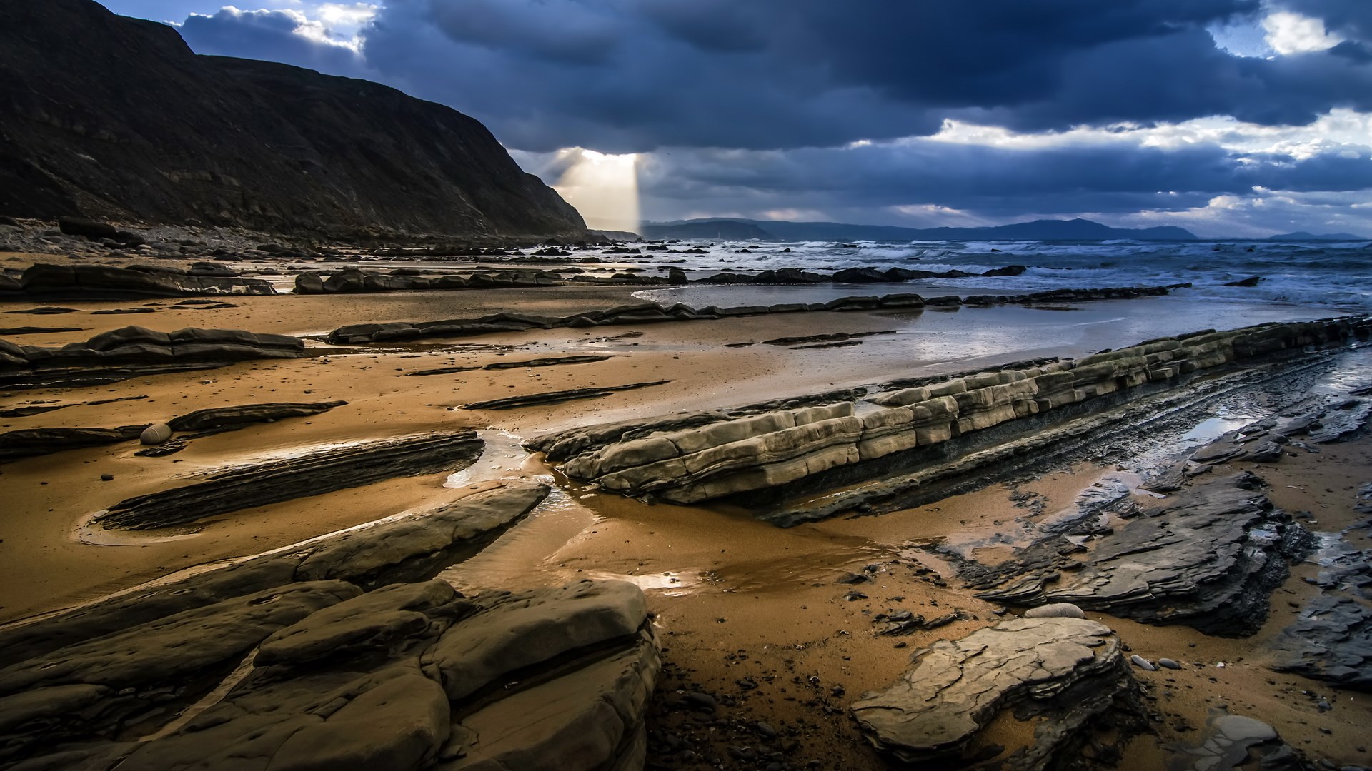 Rocky beach with dramatic clouds and ocean waves HD Wallpaper