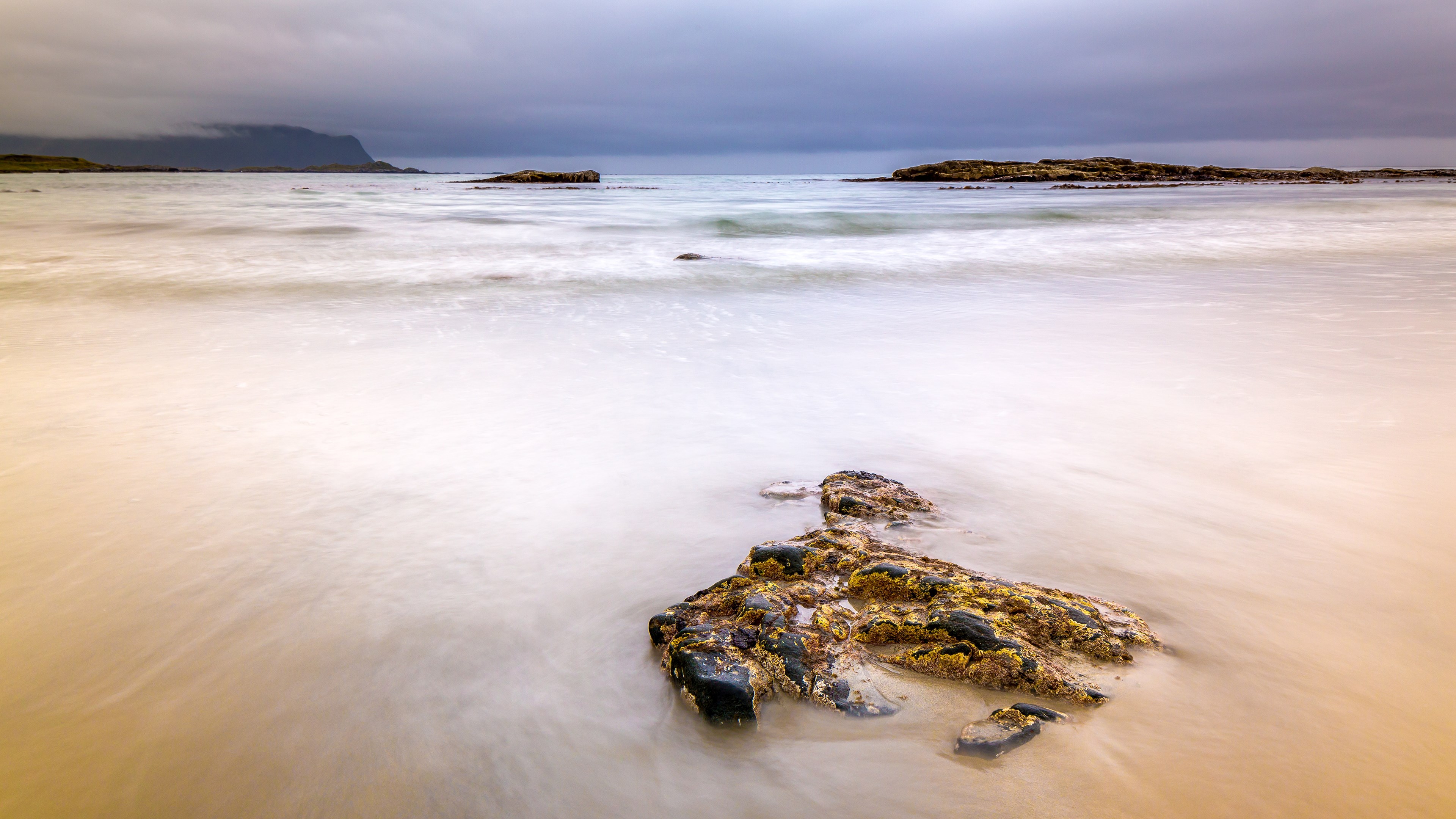 Long exposure of a rocky beach with calm ocean waves HD Wallpaper