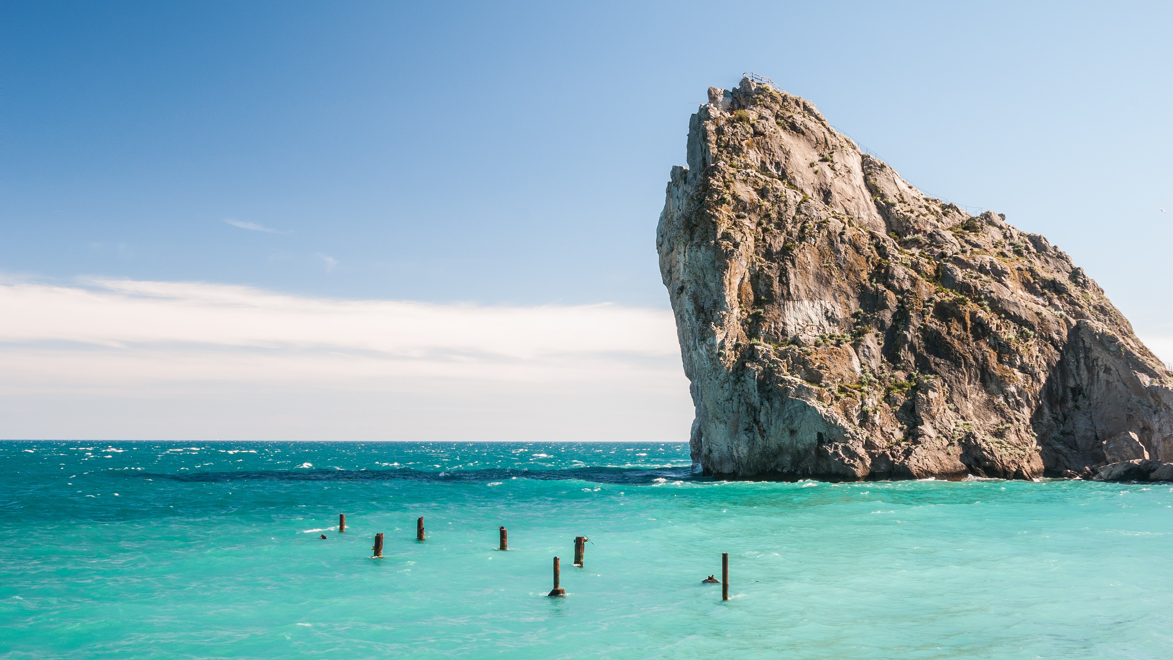 Rock formation in the sea under a blue sky HD Wallpaper