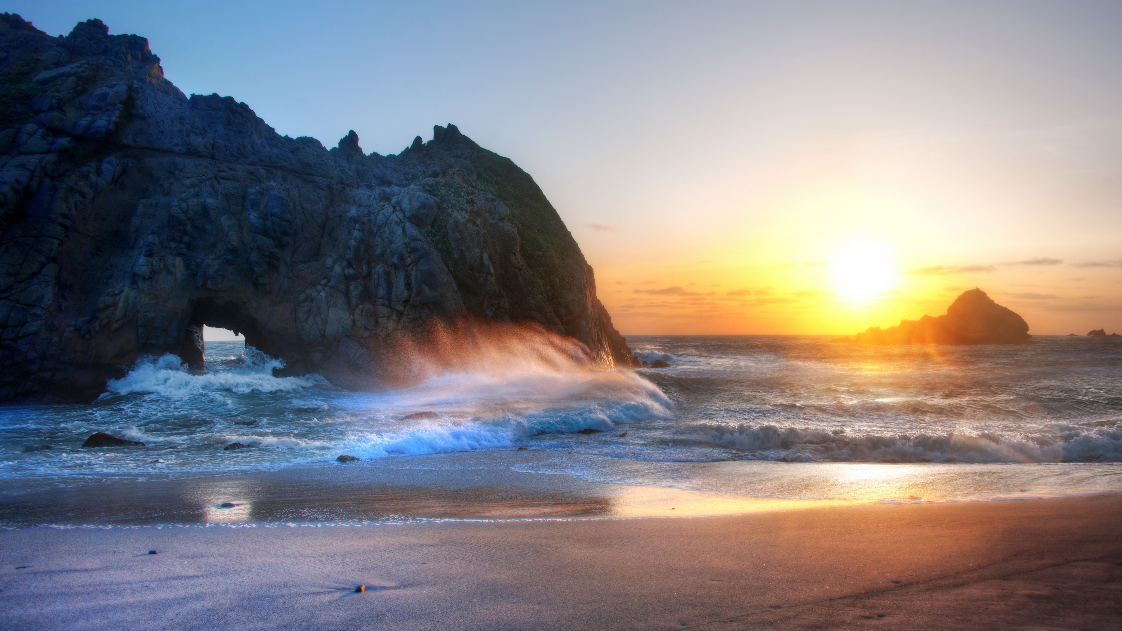 Sunset over ocean with rock arch and waves HD Wallpaper