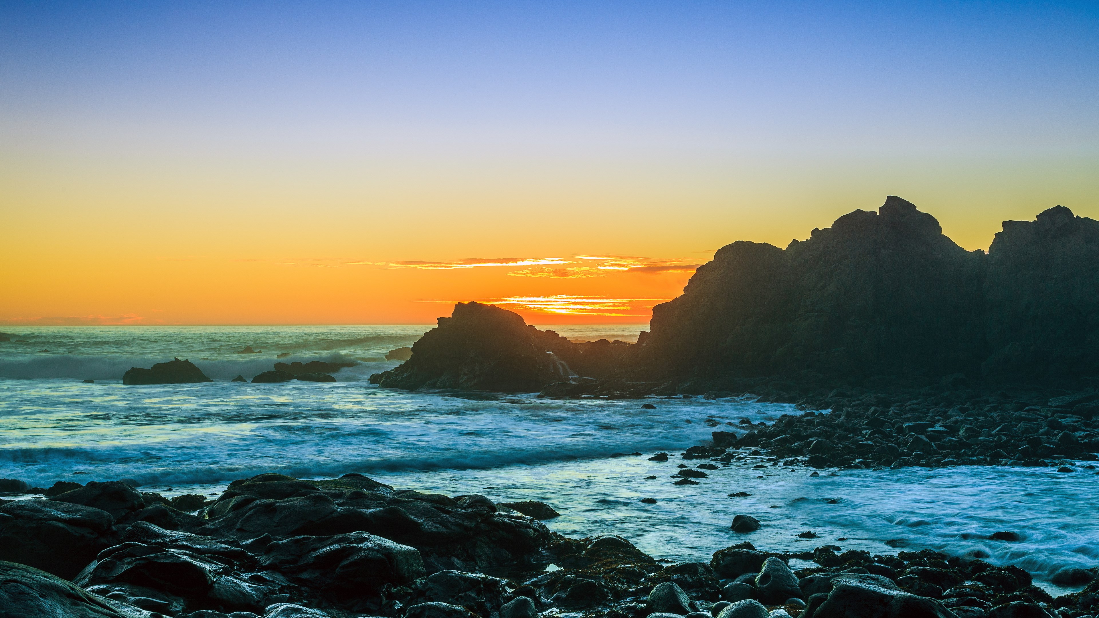 Sunset over rocky coastline with ocean waves HD Wallpaper