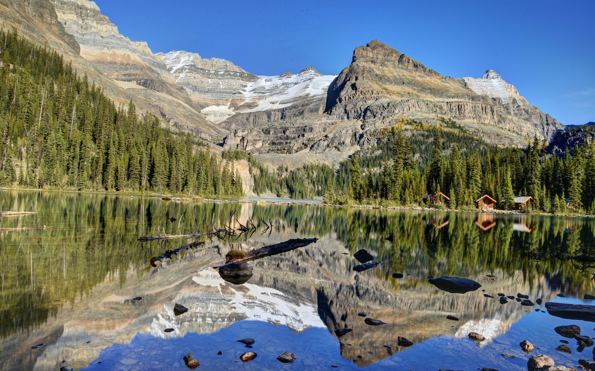 Mountain lake with cabins and reflections HD Wallpaper