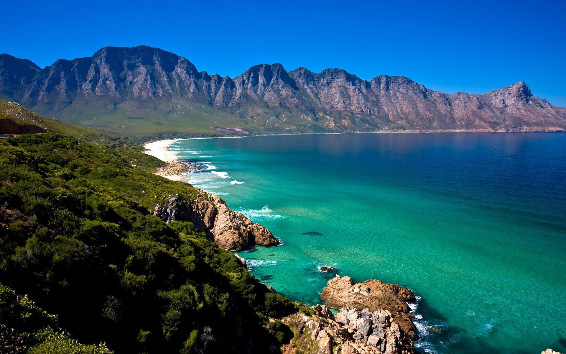 Coastal mountains meet turquoise ocean and white sand beach HD Wallpaper