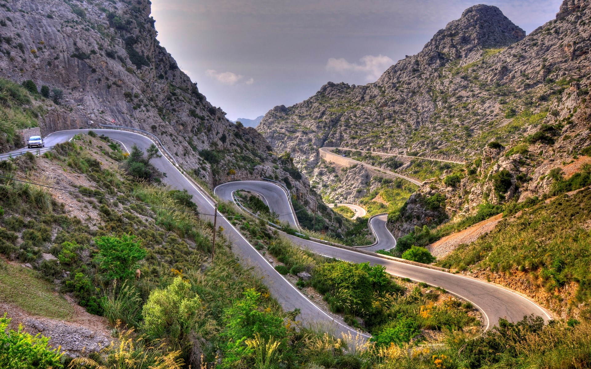 Winding mountain road with a car HD Wallpaper