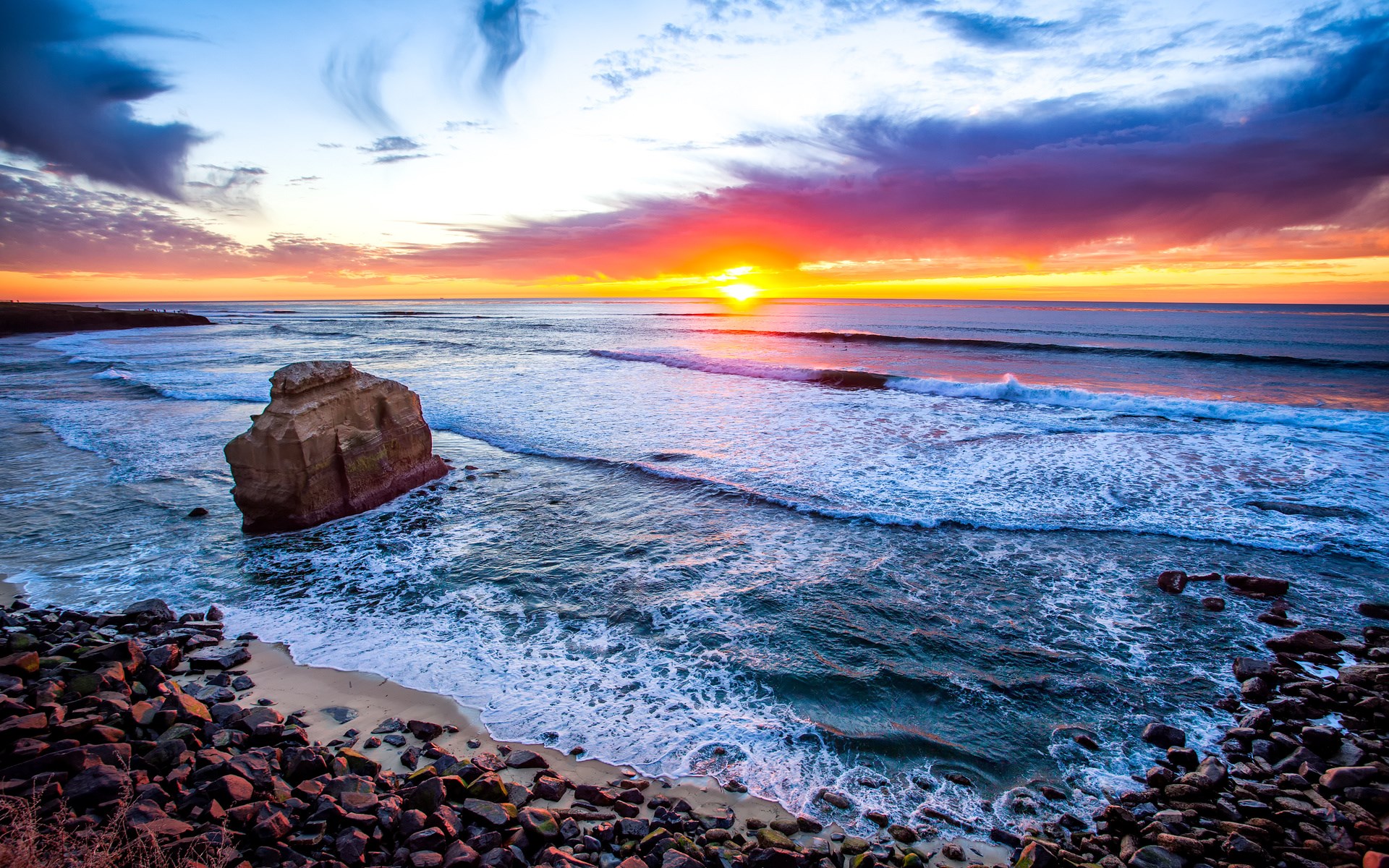 Sunset over the ocean with rock formations HD Wallpaper