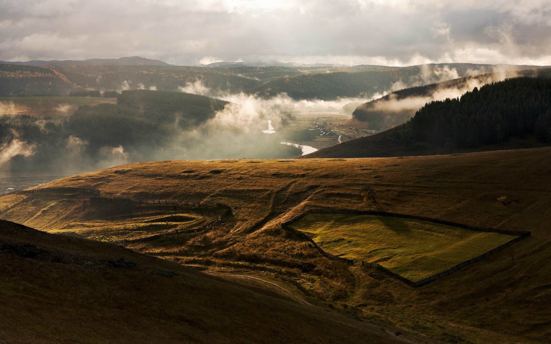 Misty valley with rolling hills and a river HD Wallpaper