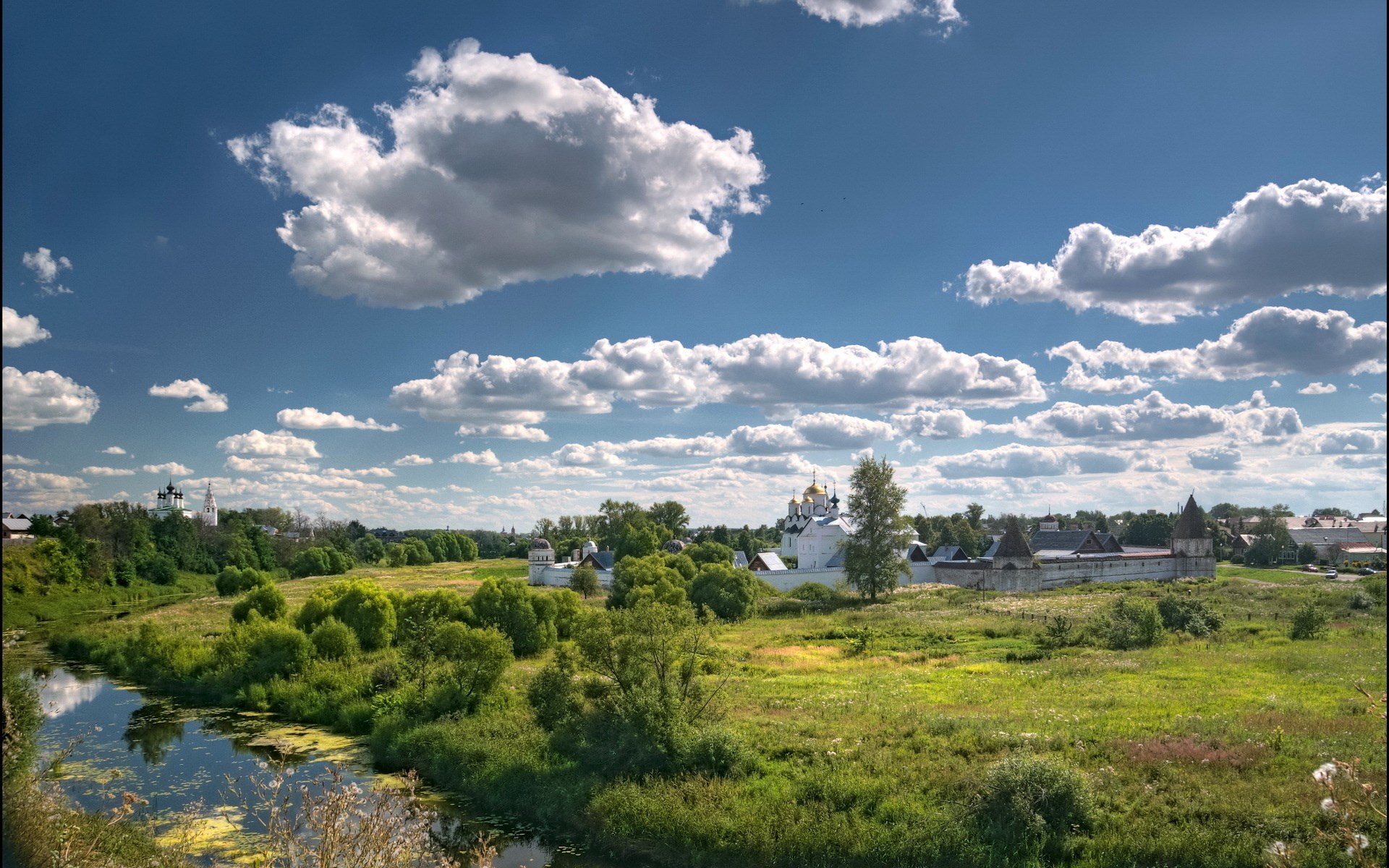 River and monastery complex under a cloudy sky HD Wallpaper