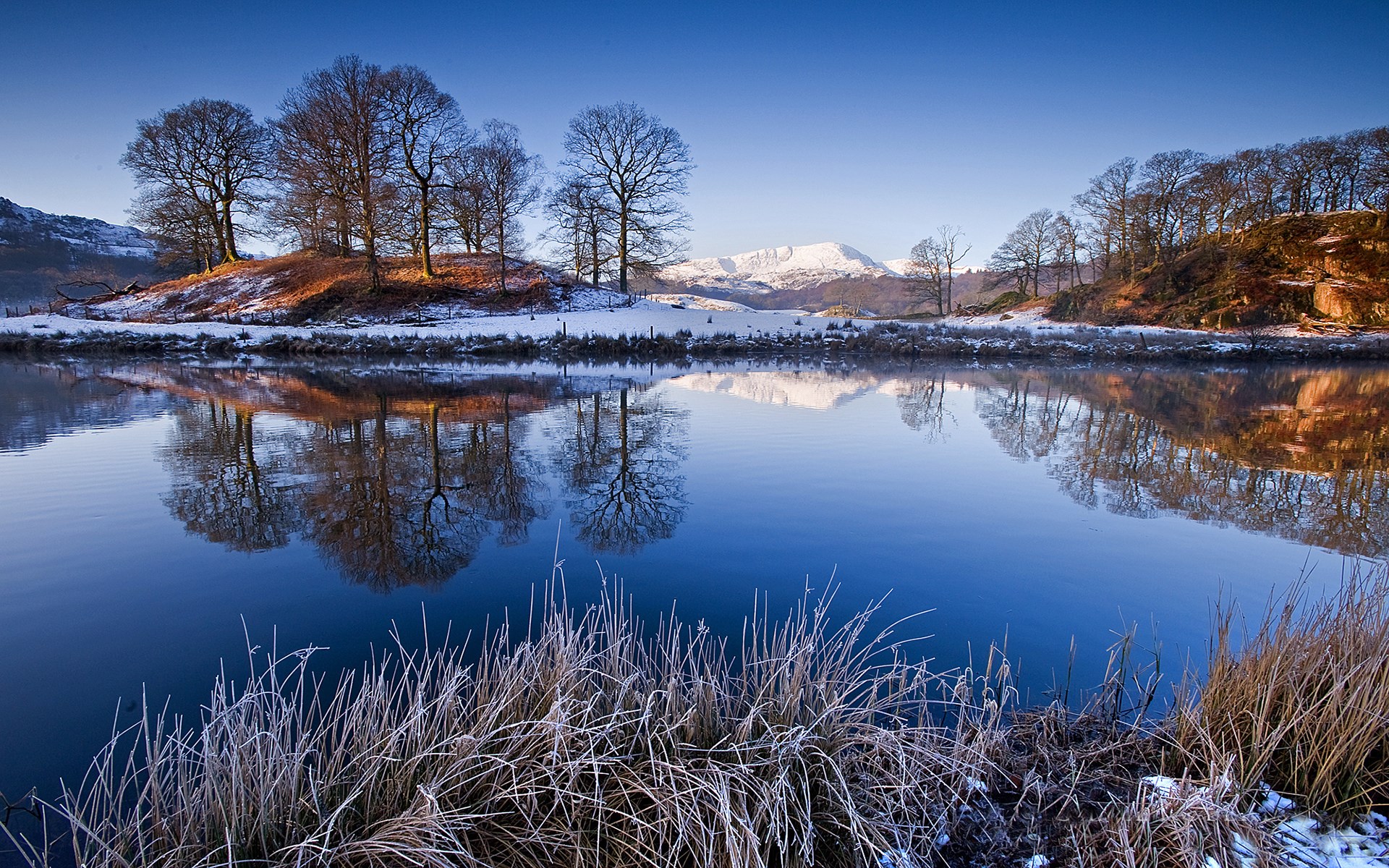 Winter landscape with snow-capped mountains and lake reflection HD Wallpaper