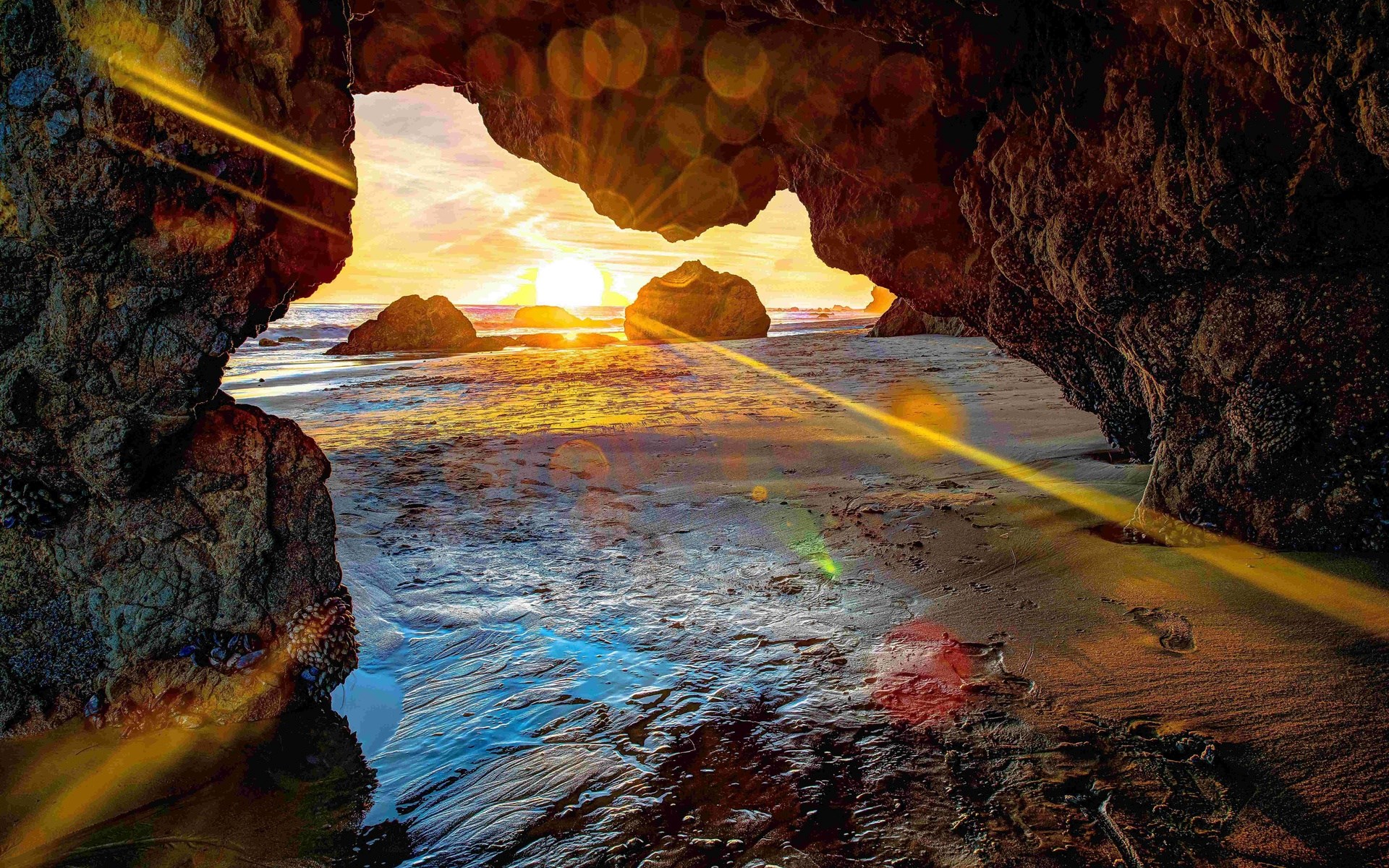 Sunset viewed from a cave on a beach HD Wallpaper