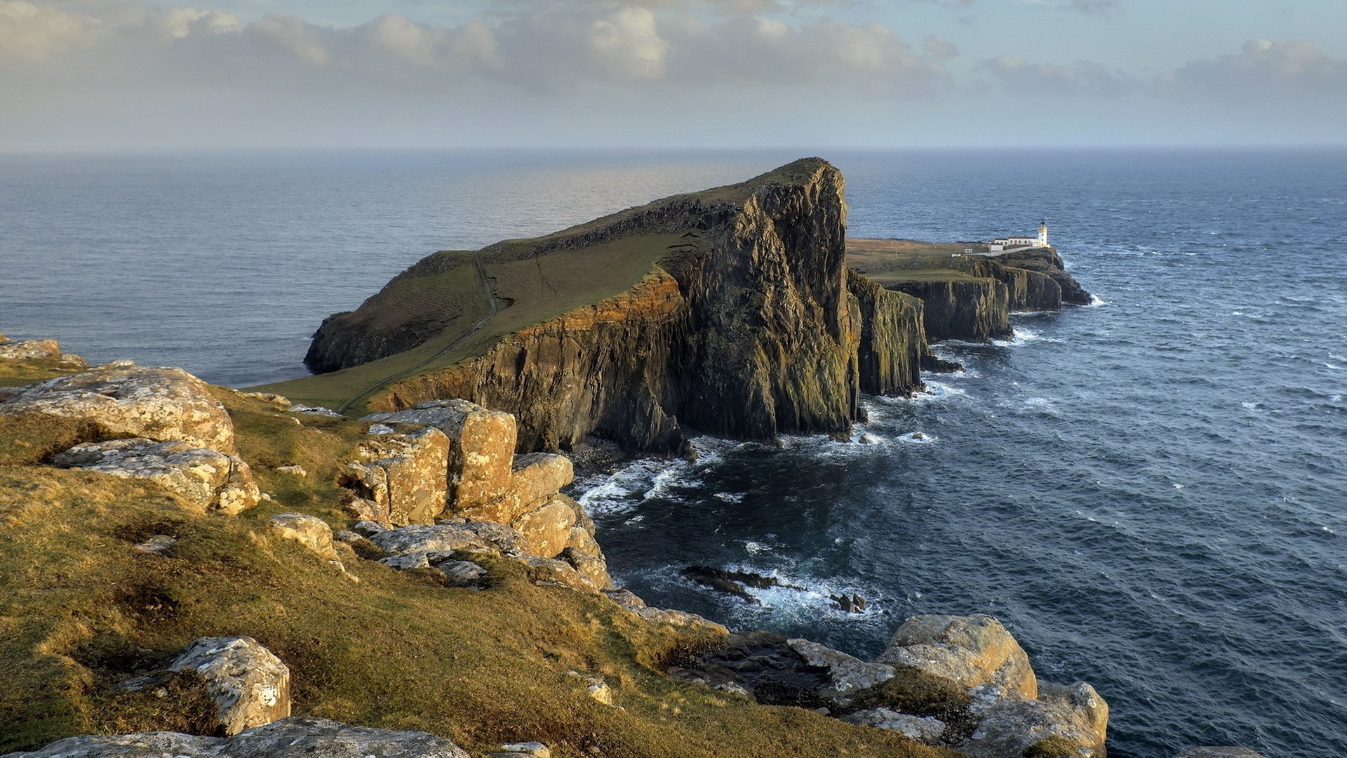 Neist Point Lighthouse on a rocky cliff overlooking the sea HD Wallpaper