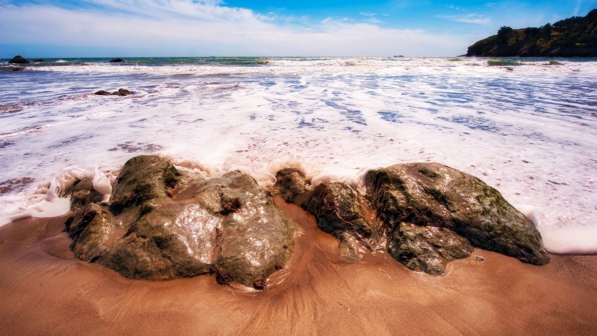 Waves crashing on rocks at a beach HD Wallpaper