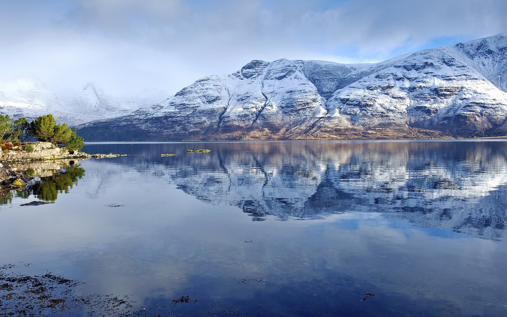 Snow-covered mountains reflected in a calm lake HD Wallpaper