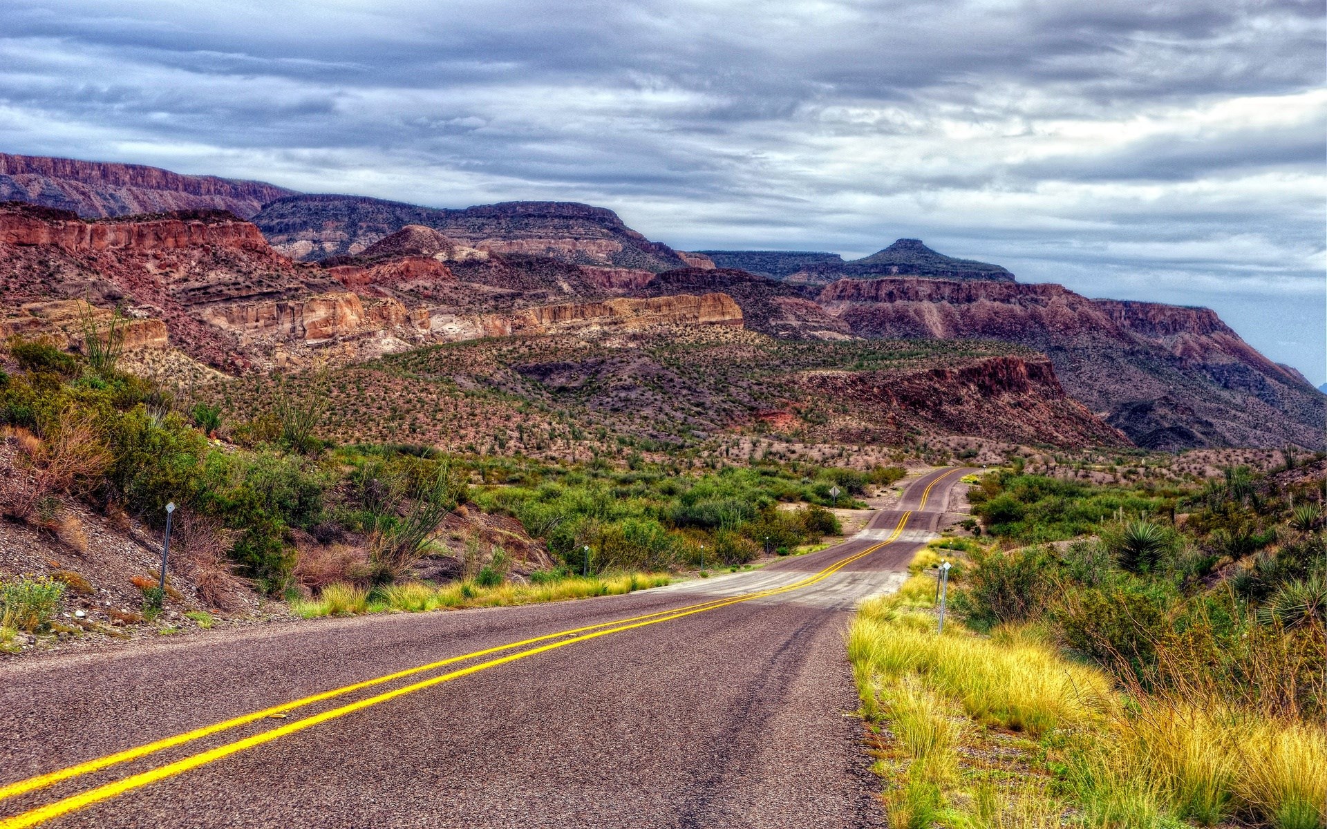 Desert road winding through mountains HD Wallpaper