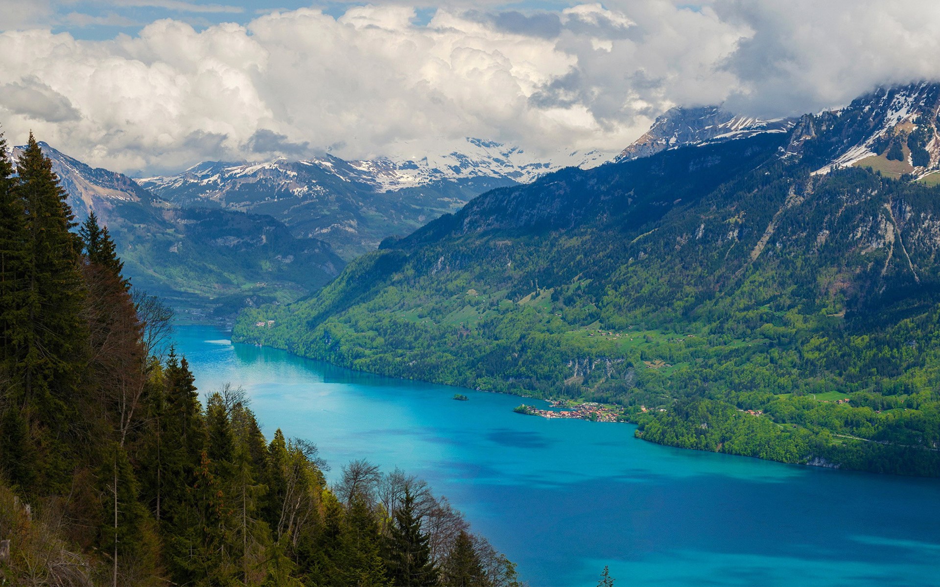 Turquoise lake surrounded by green mountains and snowy peaks HD Wallpaper