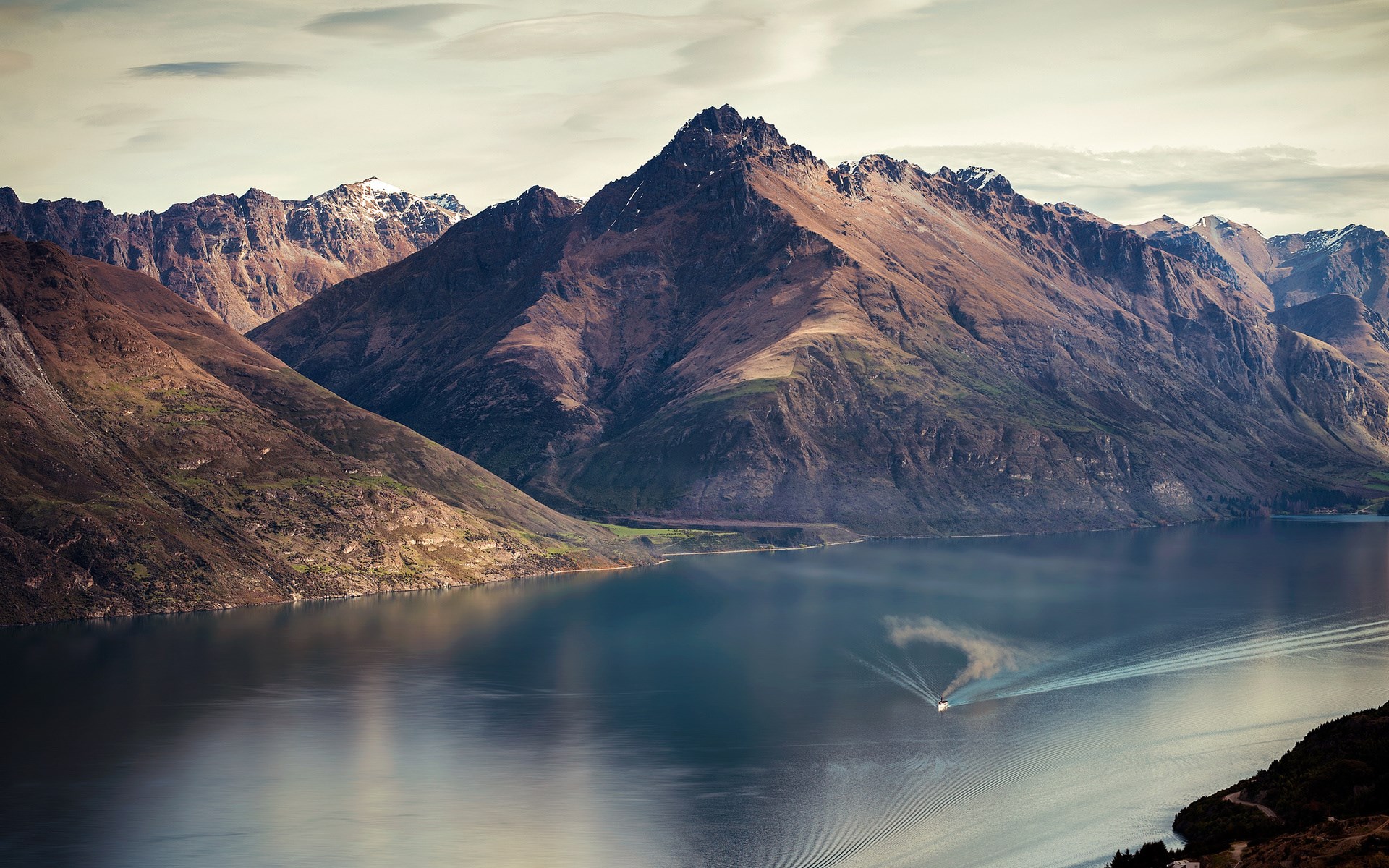 Boat on a lake with mountains in the background HD Wallpaper