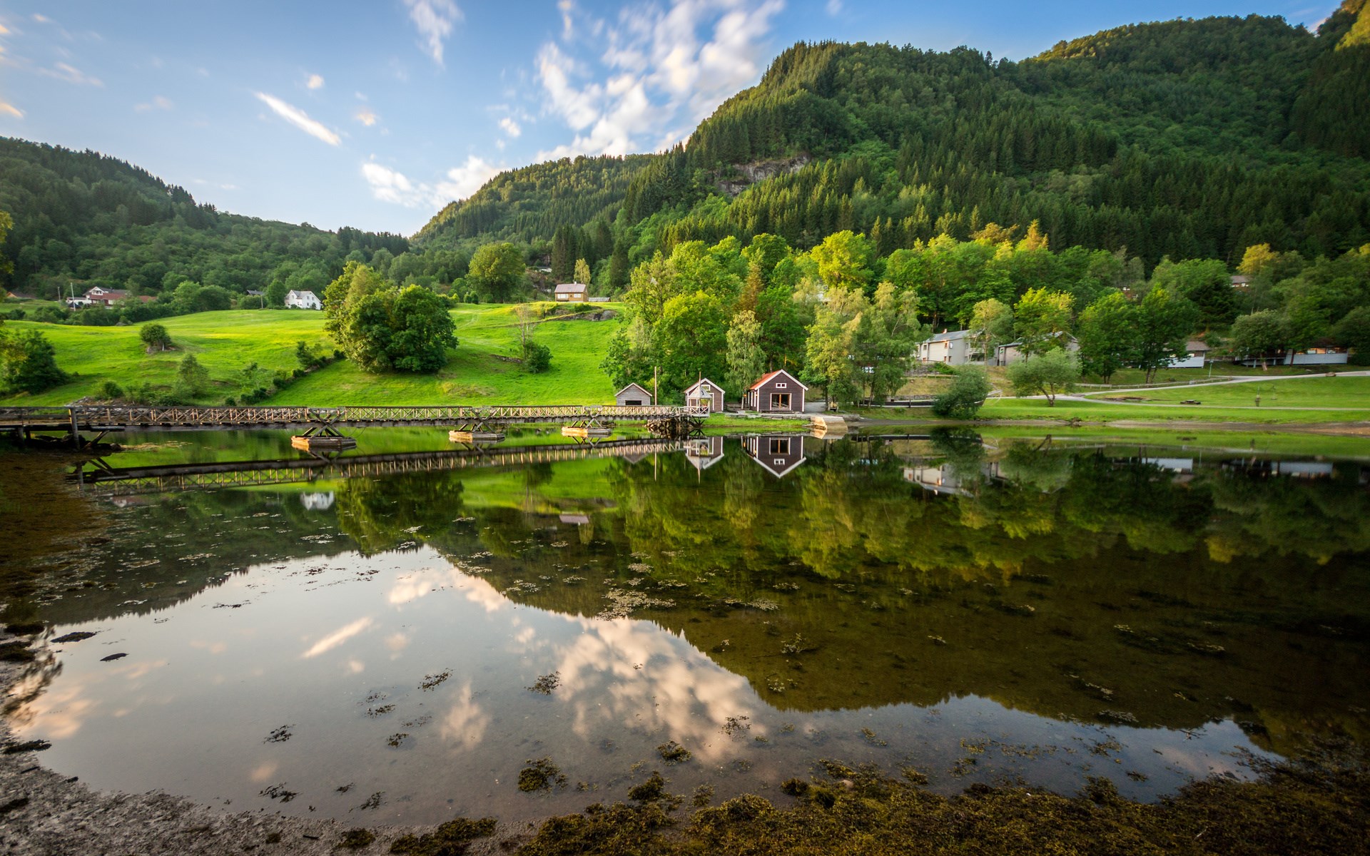 Houses on a lake with reflections and forested hills HD Wallpaper