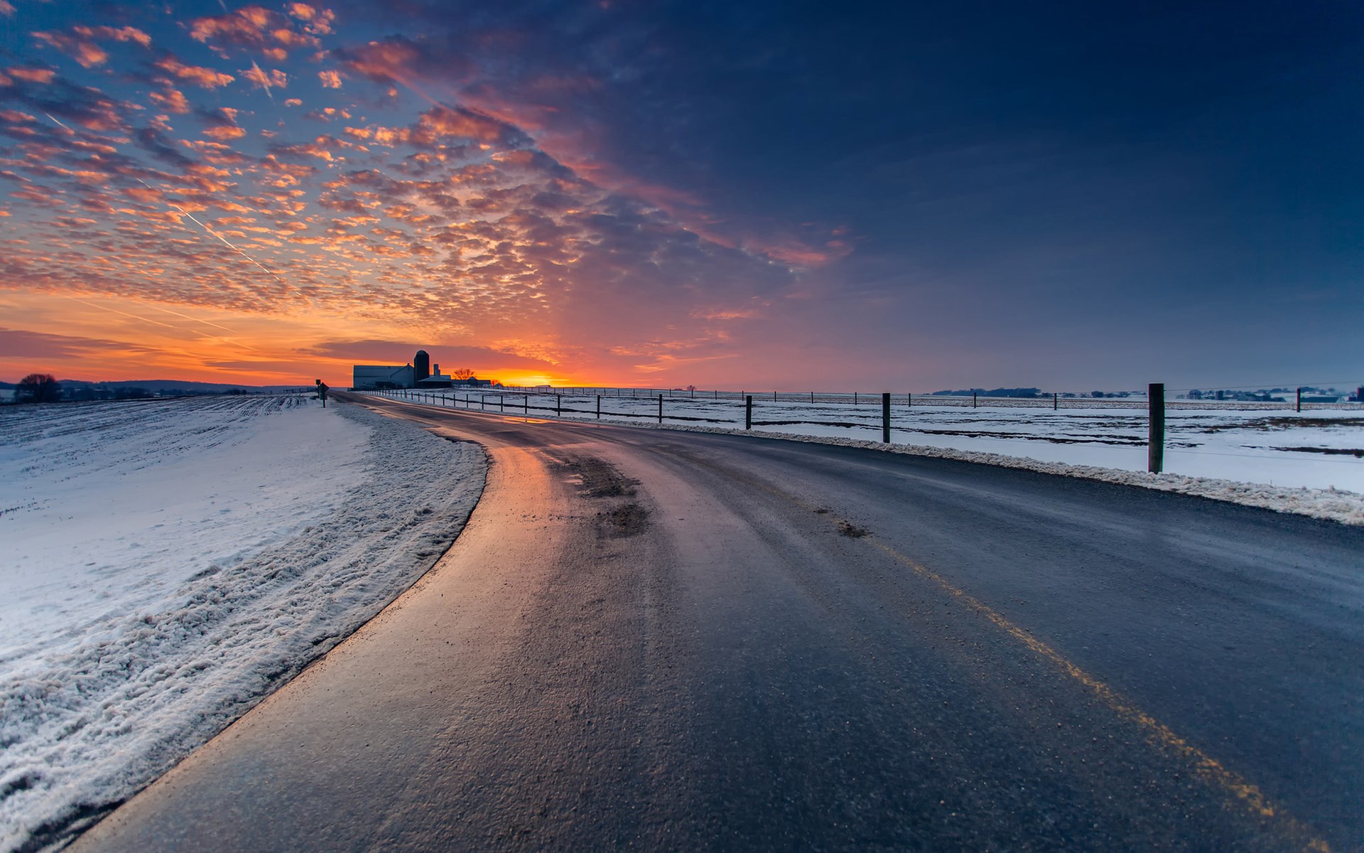Rural road at sunset with snow and farm HD Wallpaper