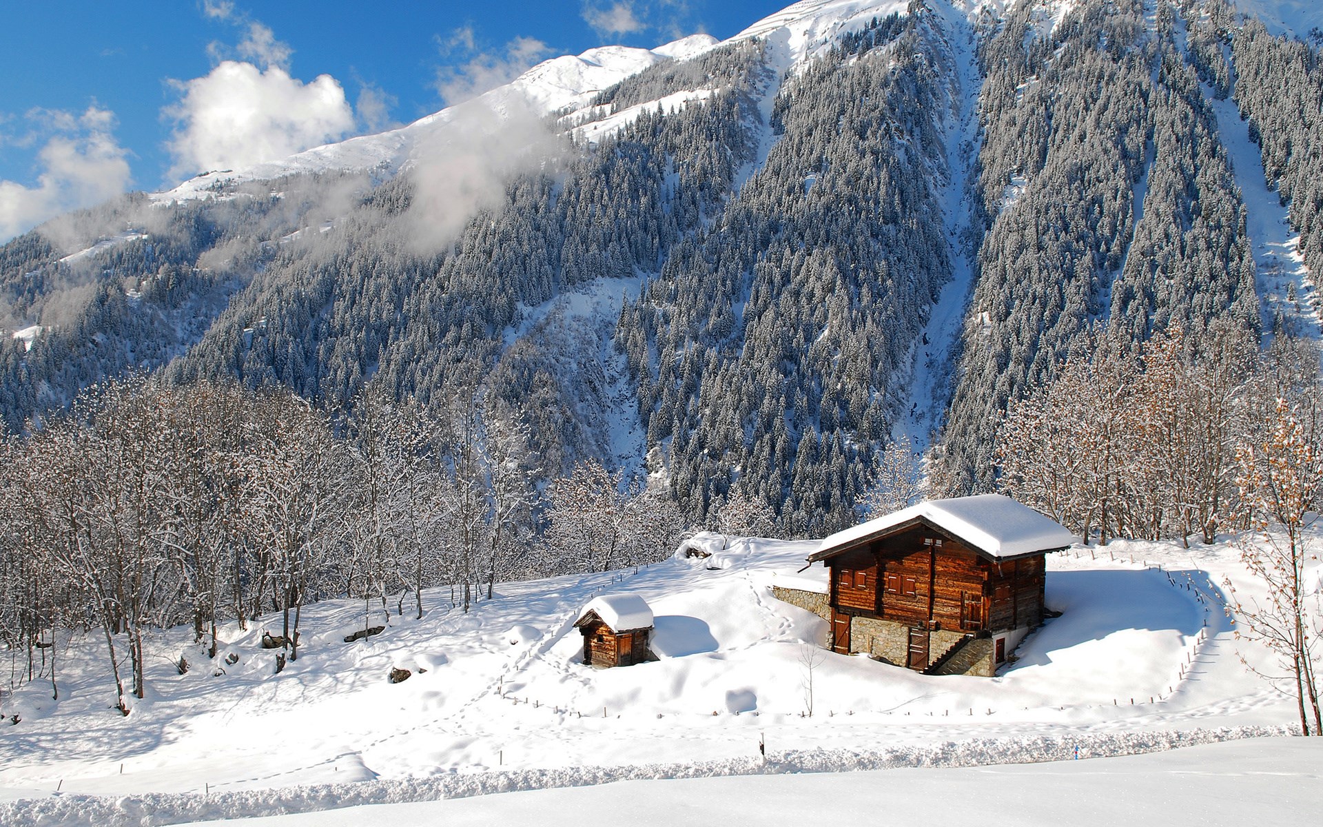 Wooden cabins in a snowy mountain landscape HD Wallpaper