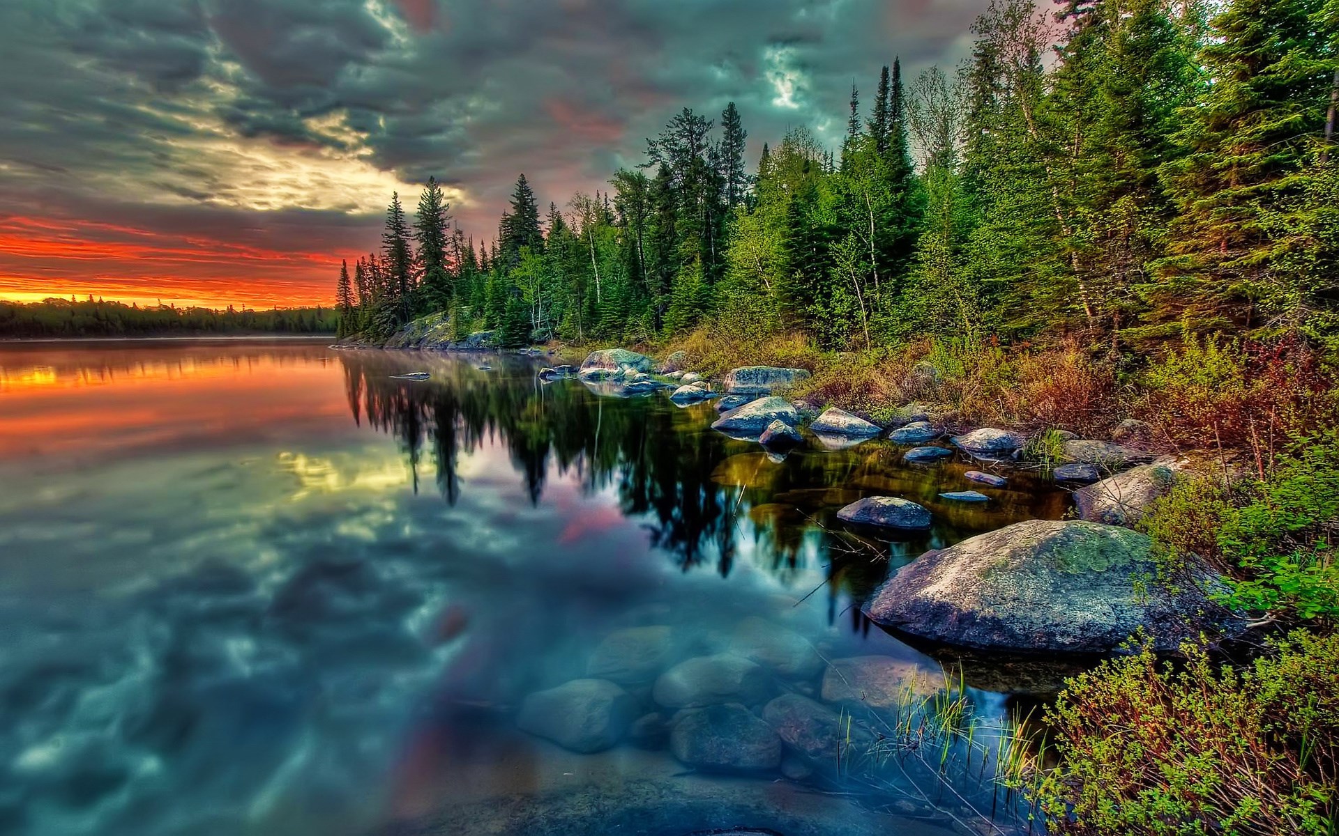 Sunset over a calm lake with a forest shoreline HD Wallpaper