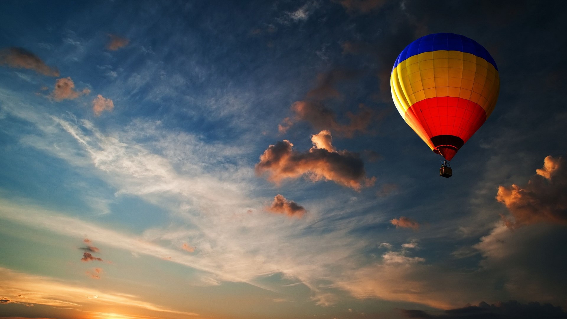 Hot air balloon flying in a cloudy sunset sky HD Wallpaper