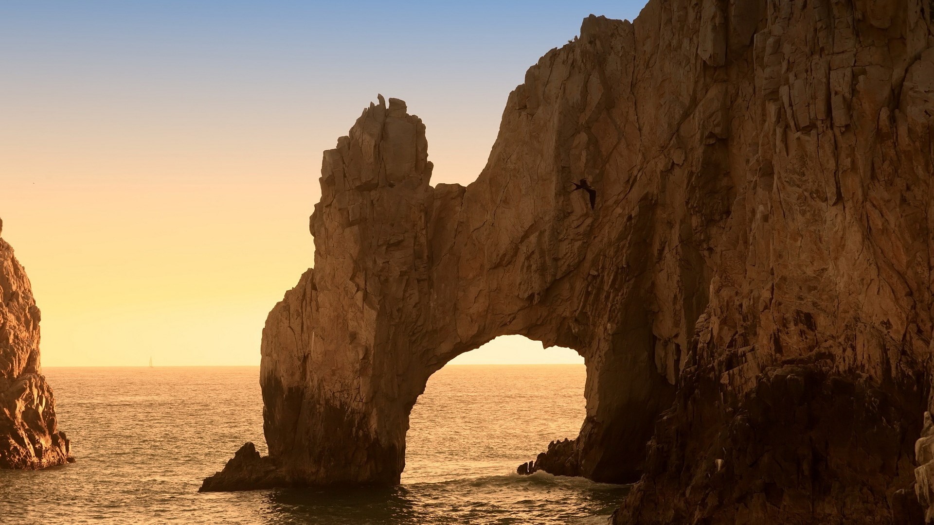 Arch rock formation over the ocean at sunset HD Wallpaper